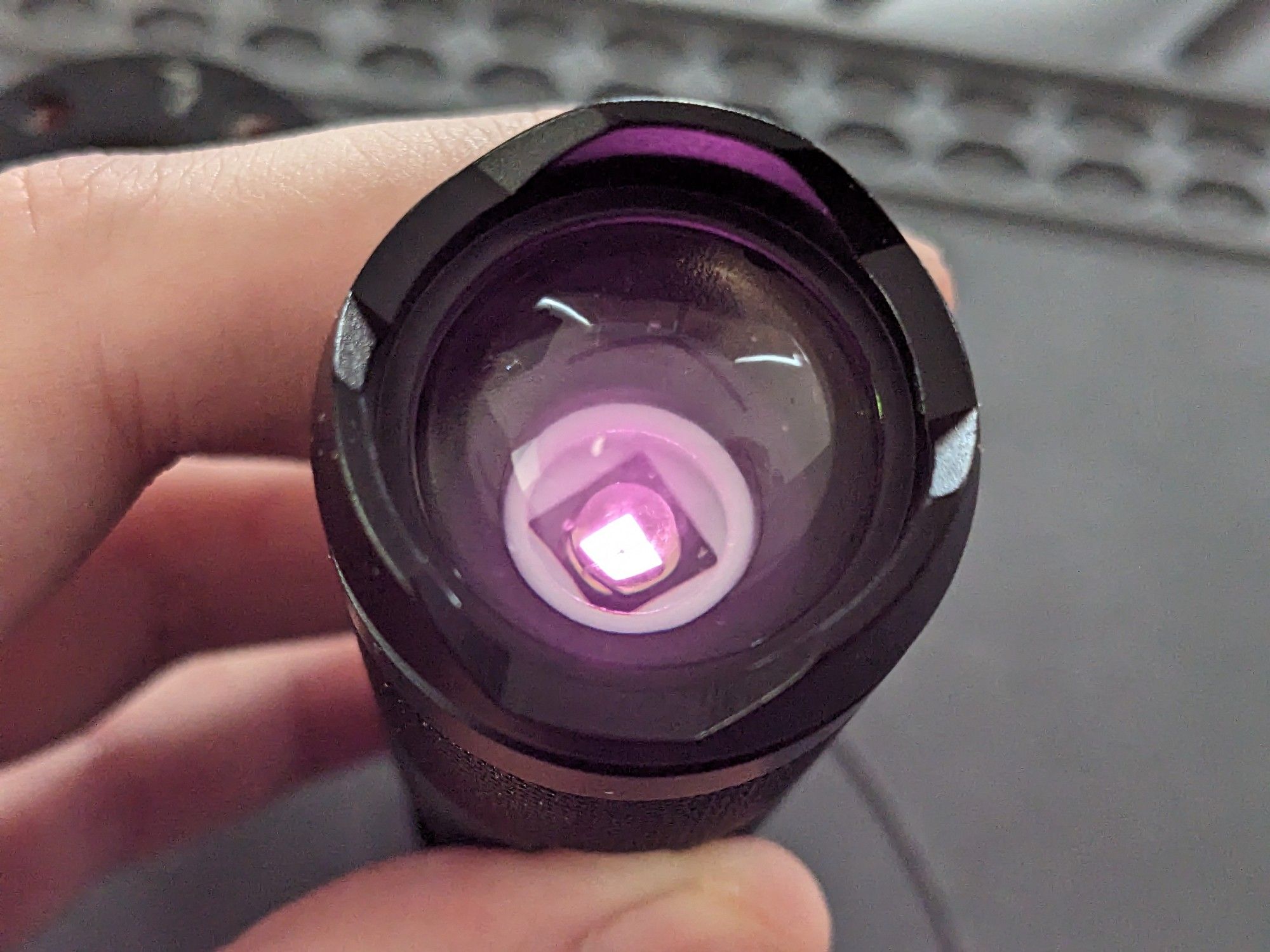 a lit flashlight photographed from the side where the light should appear, but instead of complely blinding the camera it's just dimly lit pink