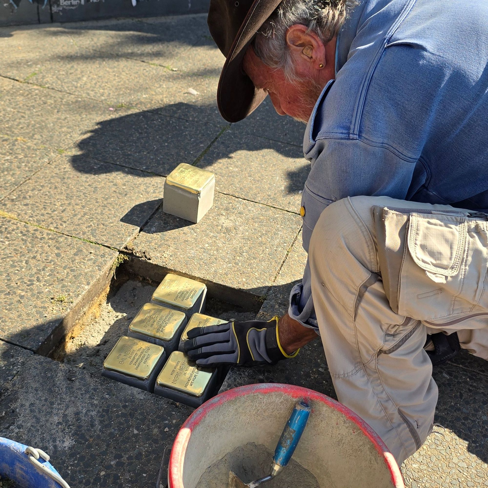 Eine Person verlegt Stolpersteine.