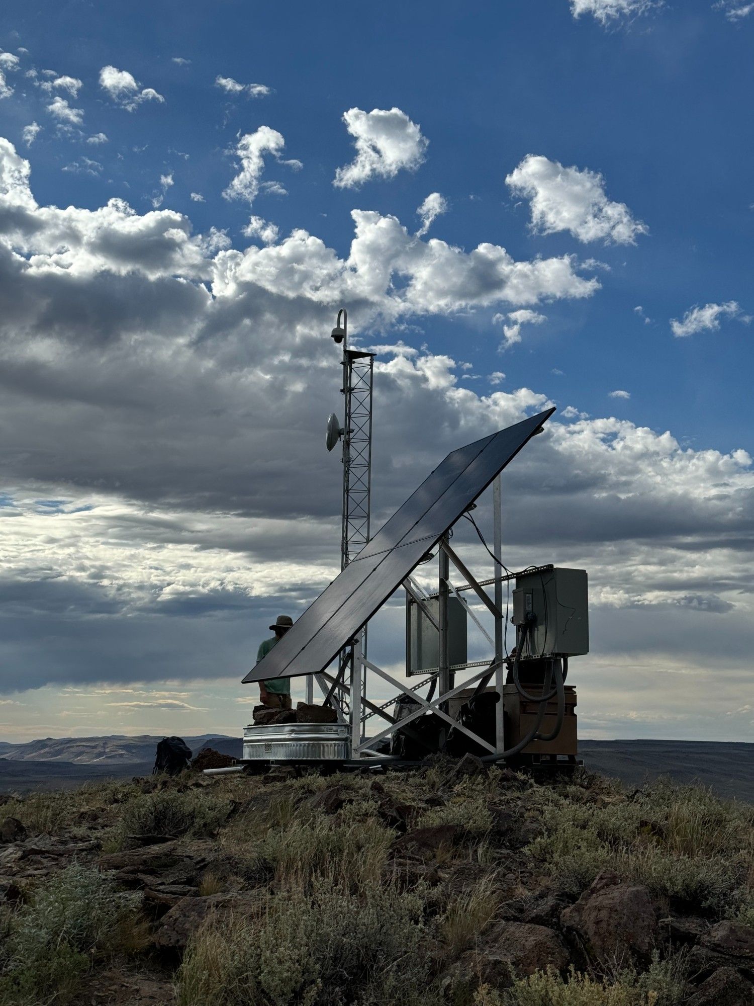 Solar panel, tower, and equipment boxes of a remote fire camera.