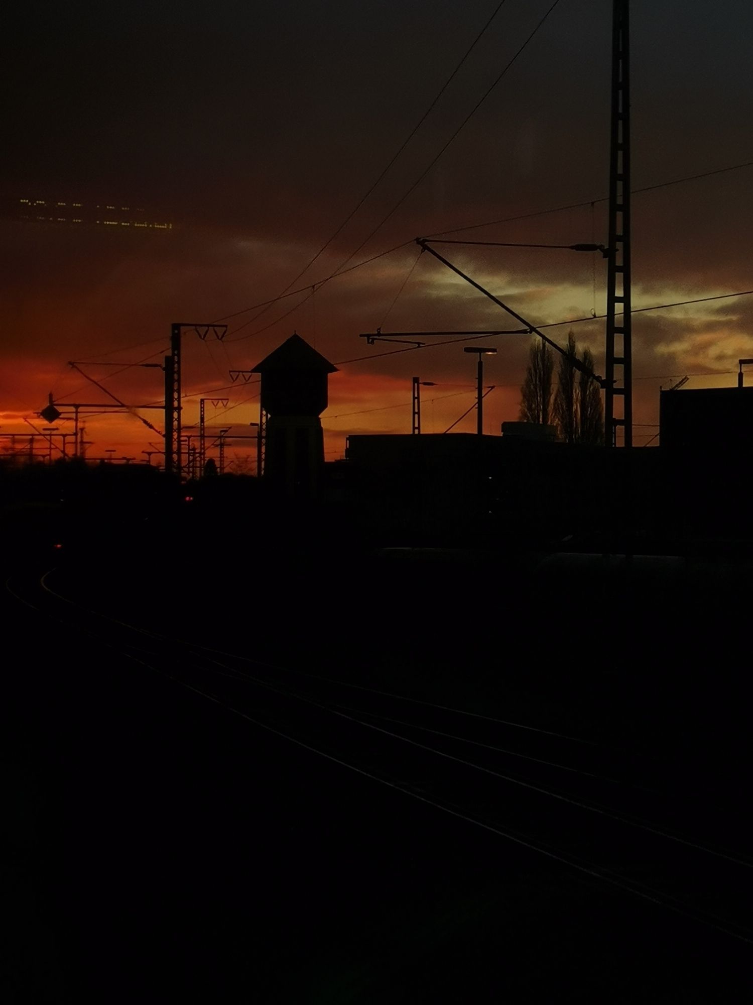 A lighthouse near of the emden train station. Lighthouse, trails and every other Objekt is black and the sky heavy orange in the sunset