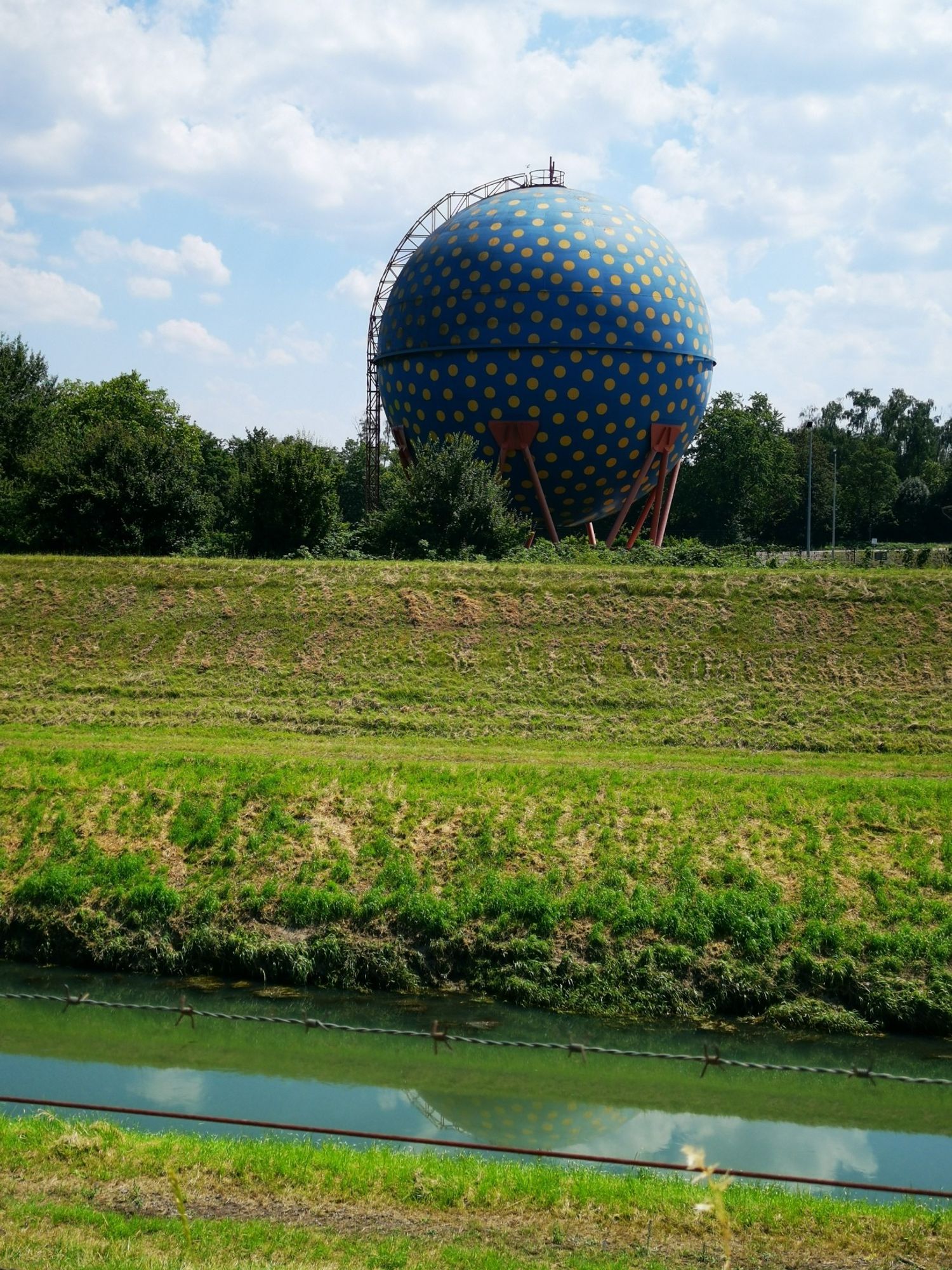 großes blaues Ei mit gelben Punkten an der Emscher (alter Fäulnisbehälter?)