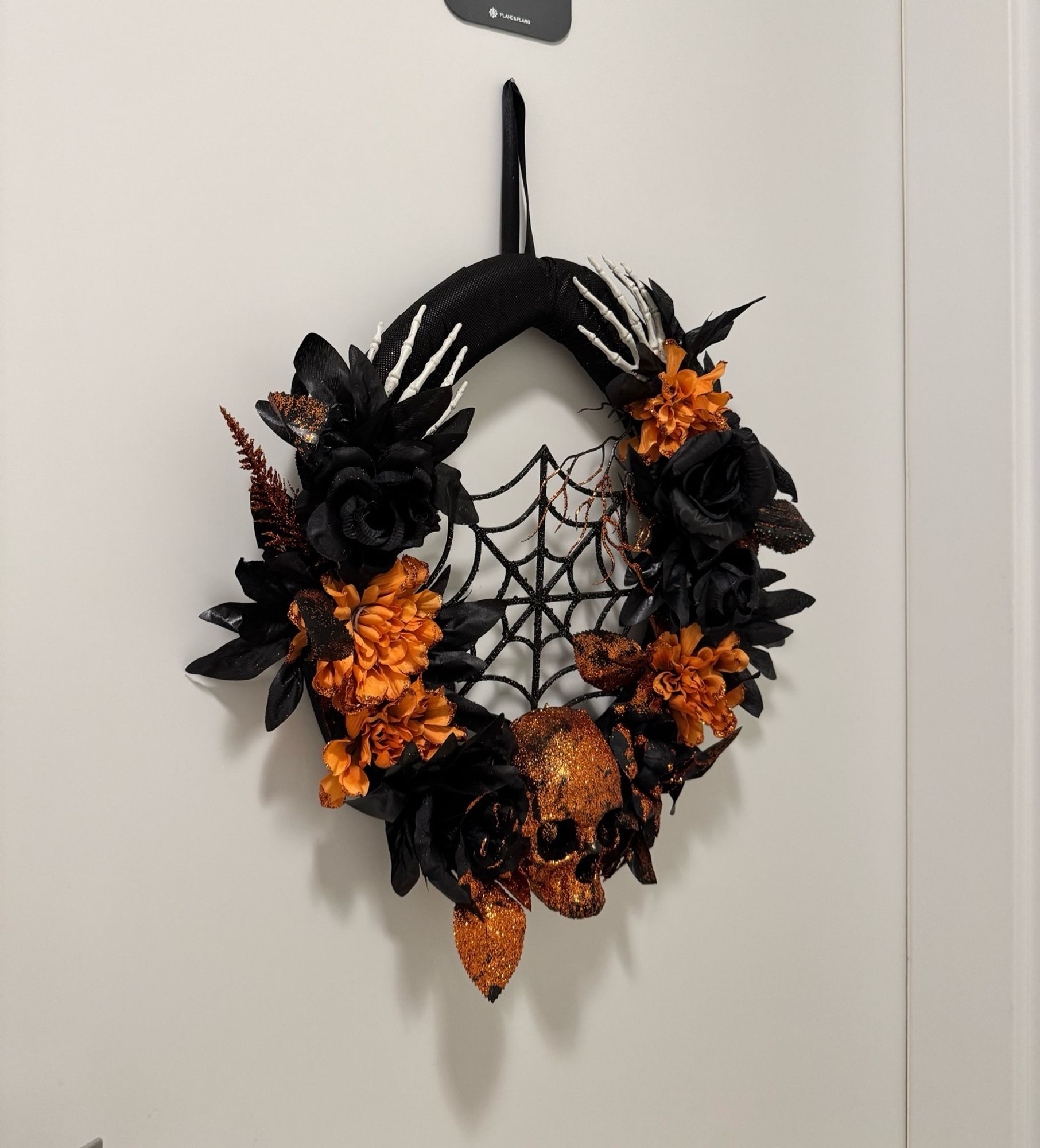 foto da porta do meu apartamento com uma guirlanda de halloween