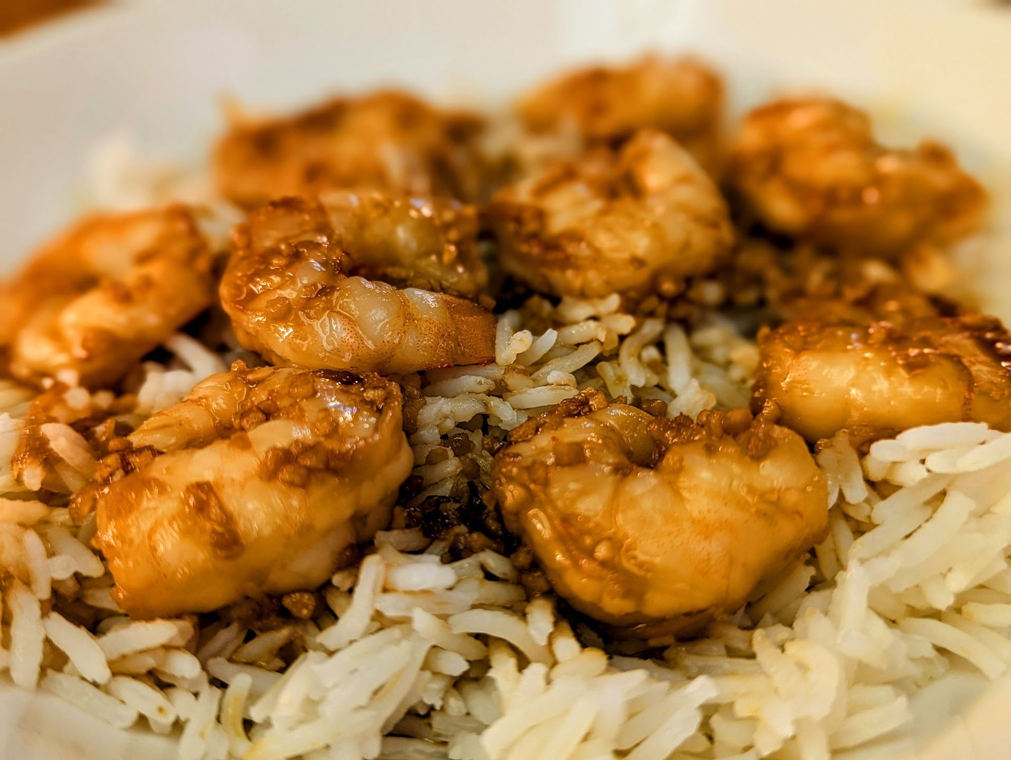 Bowl of honey-garlic shrimp on rice.