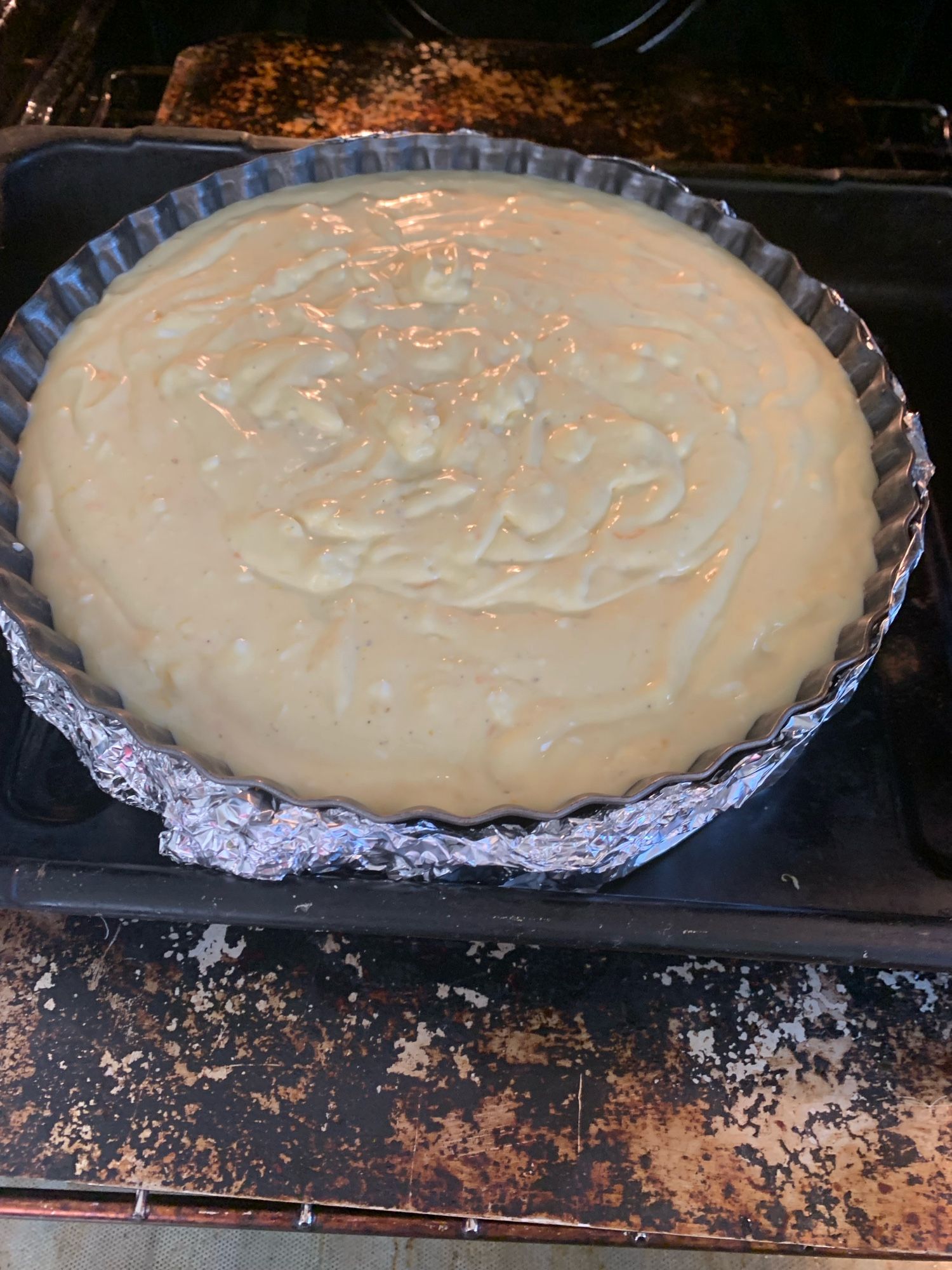 One lemon and orange baked cheesecake going into the oven Bain marie