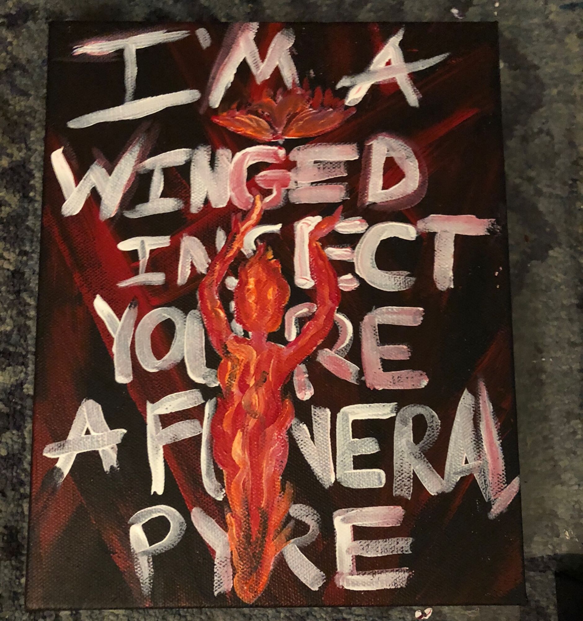 An abstract background with reds and black has white text that says “I’m a winged insect, you’re a funeral pyre” lyrics to a song by Sleep Token called “Take Me Back to Eden”

In the foreground is a flaming moth flying towards a woman made of flames