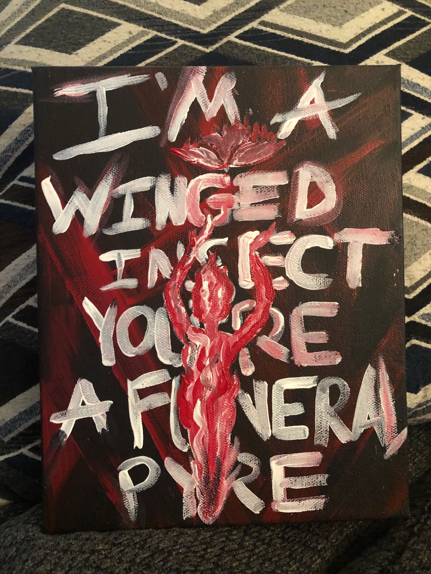 A painting with a woman made of flames enticing a flaming moth to her with the lyrics from “Take Me Back To Eden” from Sleep Token stating “ I’m a winged insect, you’re a funeral pyre”