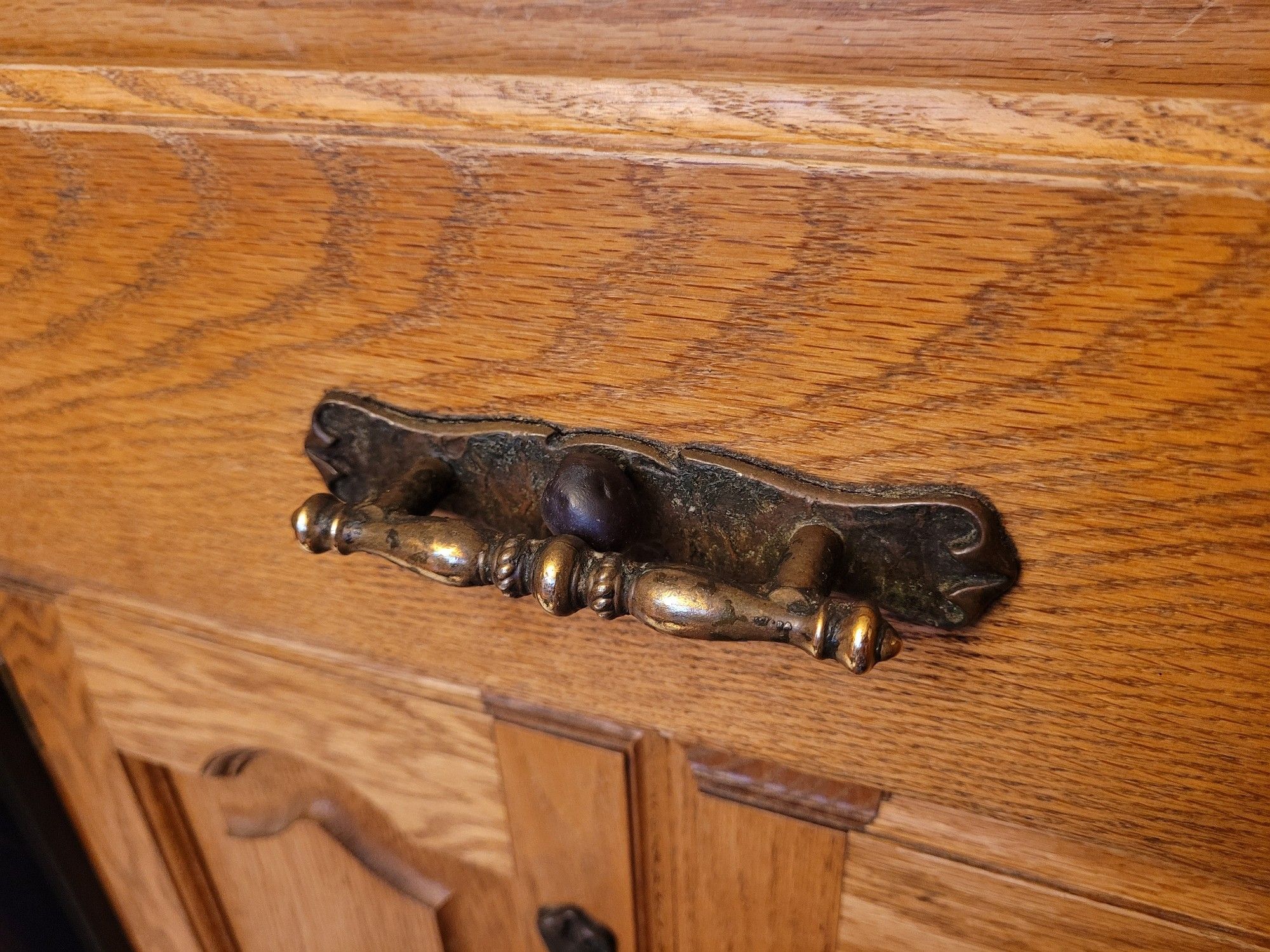 One grape precariously perched on a drawer handle