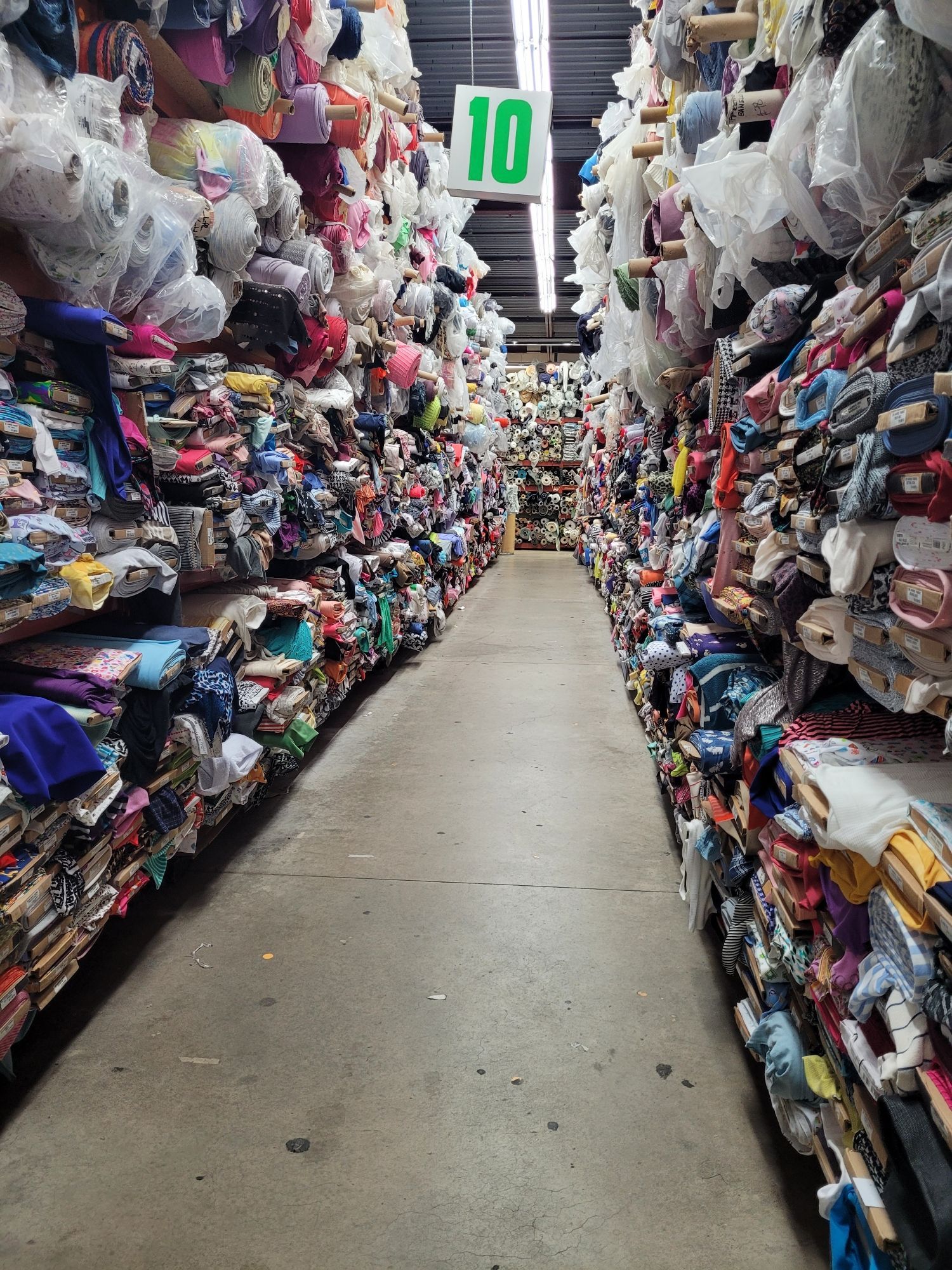 An aisle at the fabric store overloaded with fabric