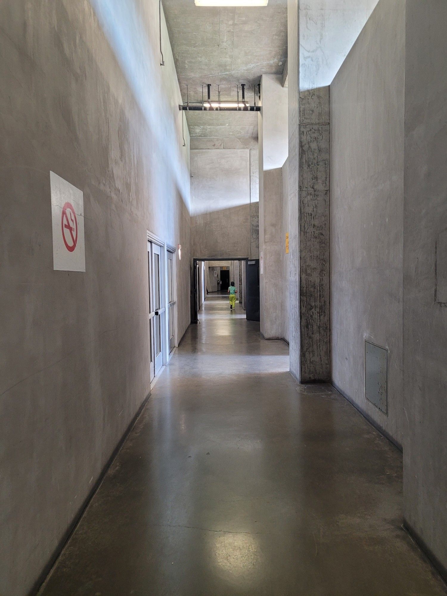 A bare concrete corridor, with concrete walls, concrete floor, and bare fluorescent lights ever 10 yards. This is literally how you approach your seats at this stadium.