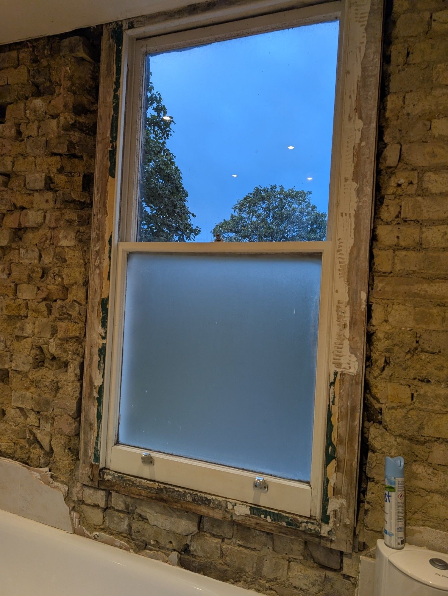 Photo of a window surrounded by exposed and shoddy brickwork