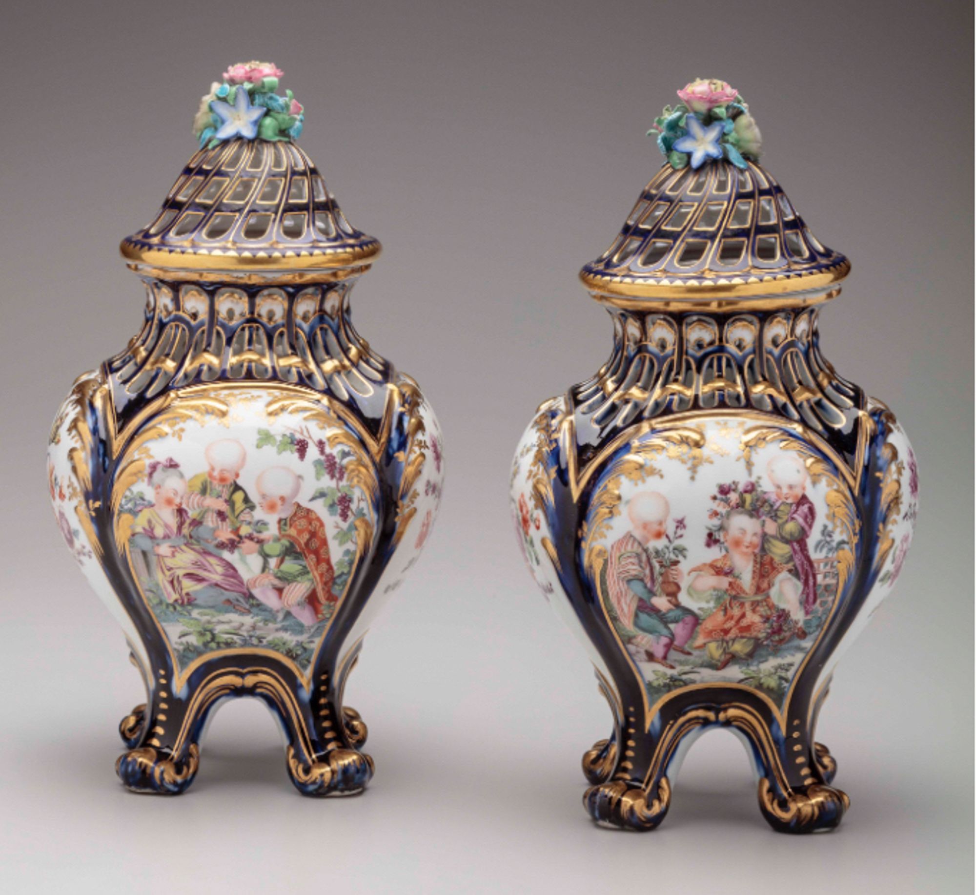 Vases with pierced openings to let out the fragrant smoke of the pastille. Dark blue ground with large scenes of children (derived from Boucher chinoiseries), lashings of gilding, floral finials. Based on Vincennes originals