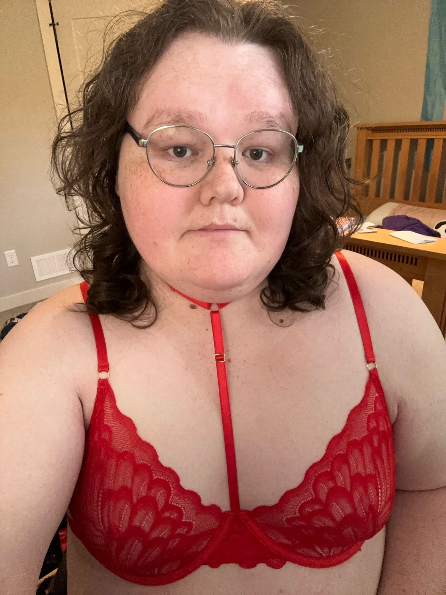 A selfie of Amelia in a red lacy lingerie bra