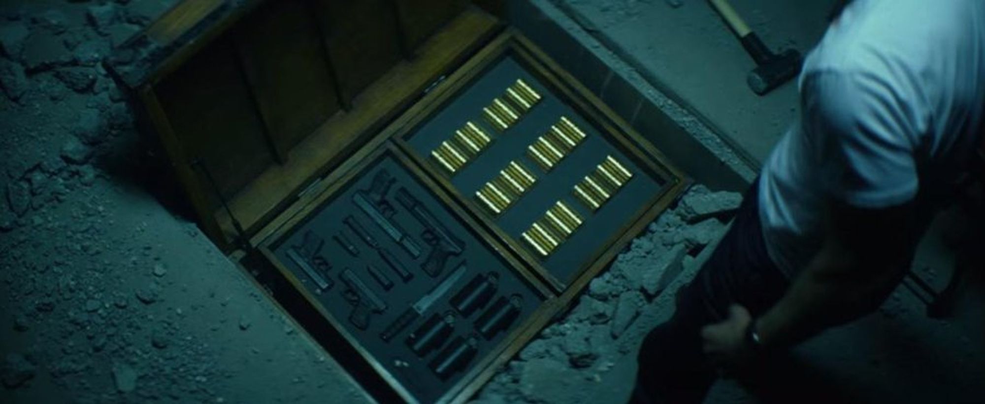 Still from "John Wick", a case of guns and gold coins.