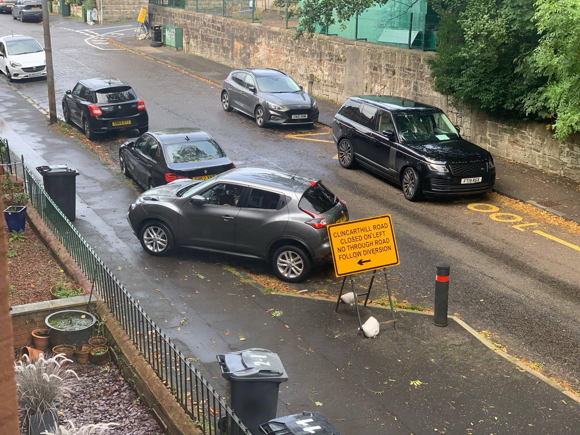 A car parked diagonally on a pavement.