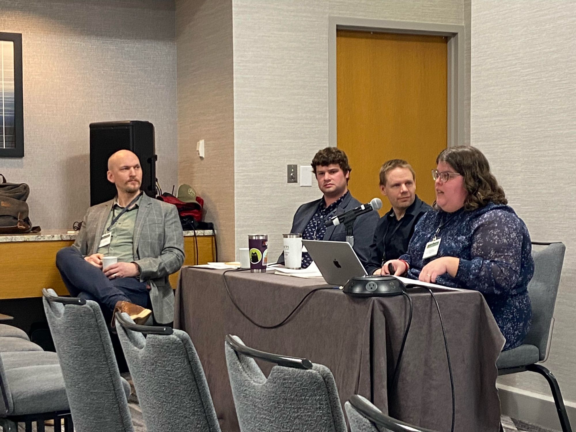 Joshua MacFadden, Zachary Tingley, Glenn Iceton, and Erin Spinney presenting at ASEH. Three men and one woman sitting at a long table speaking at a conference.