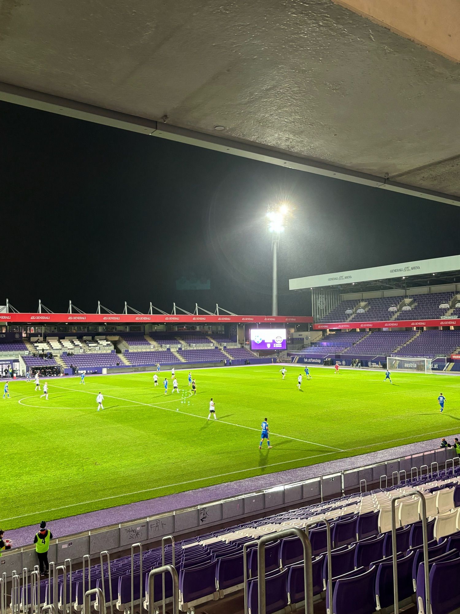 Innenansicht Generali Arena in Wien, Ränge fast leer. Spieler sind zu sehen.