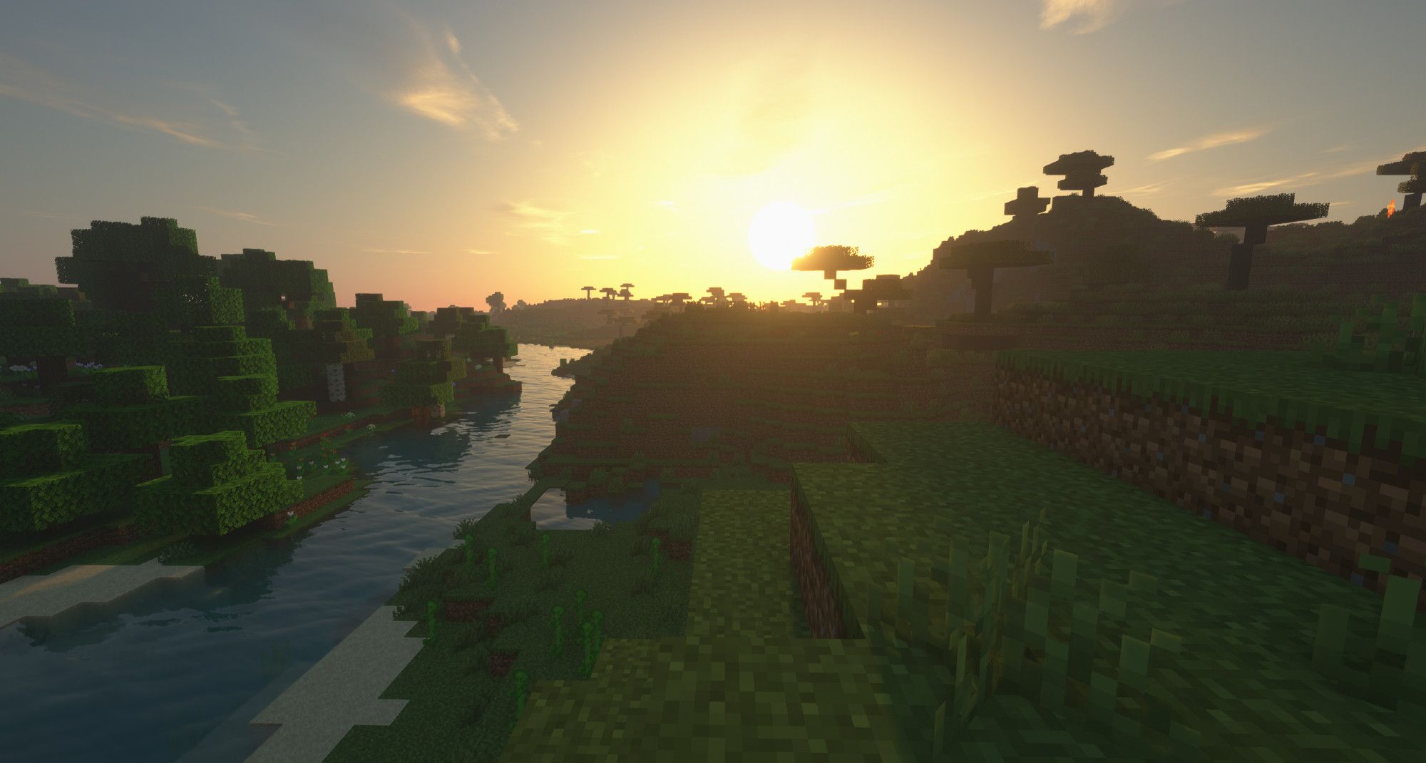 Screenshot de Minecraft où on voit une vallée avec une rivière et un lever de soleil en fond