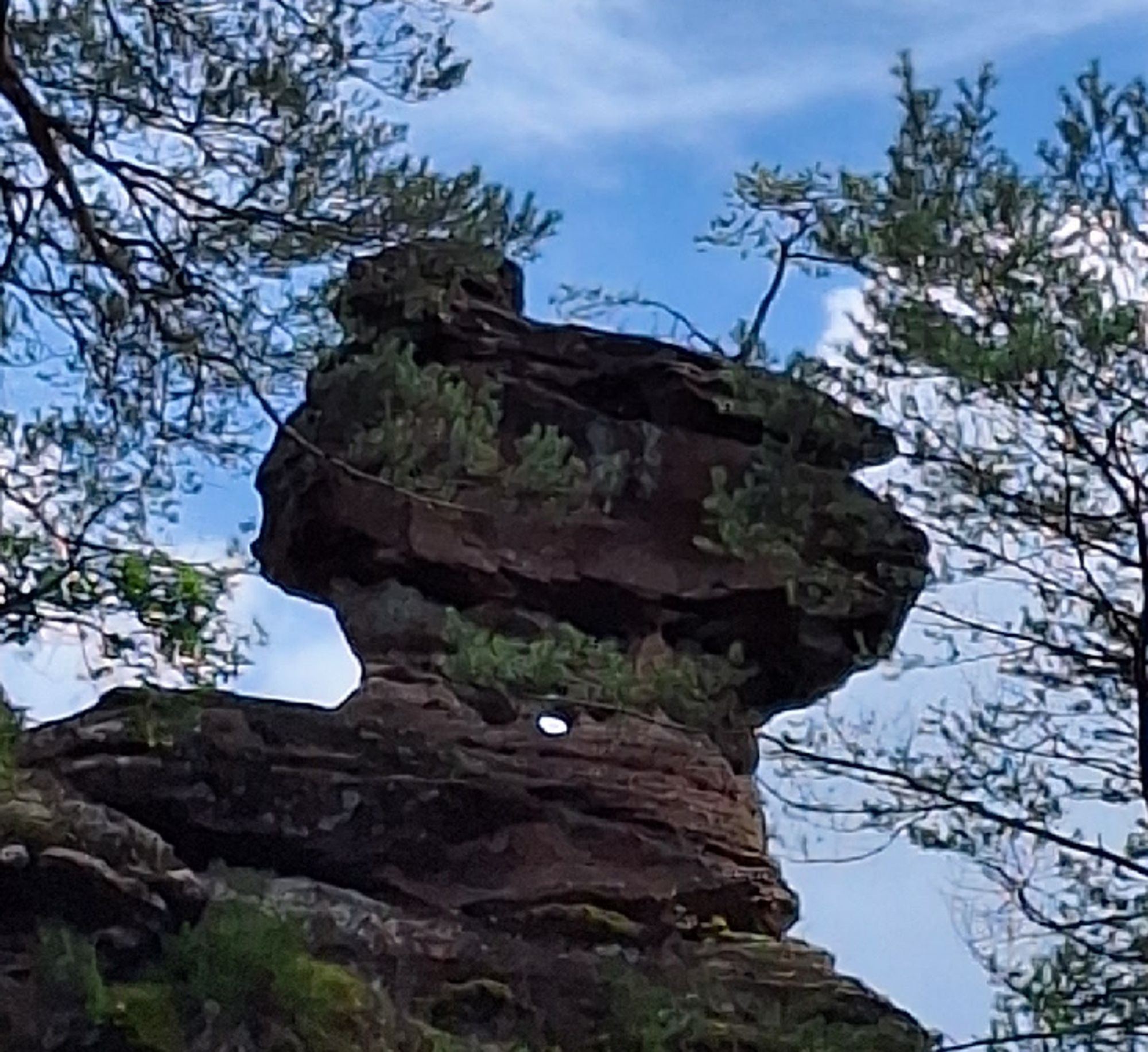 Ein torförmiger Felsen mit einem runden Loch mittig.