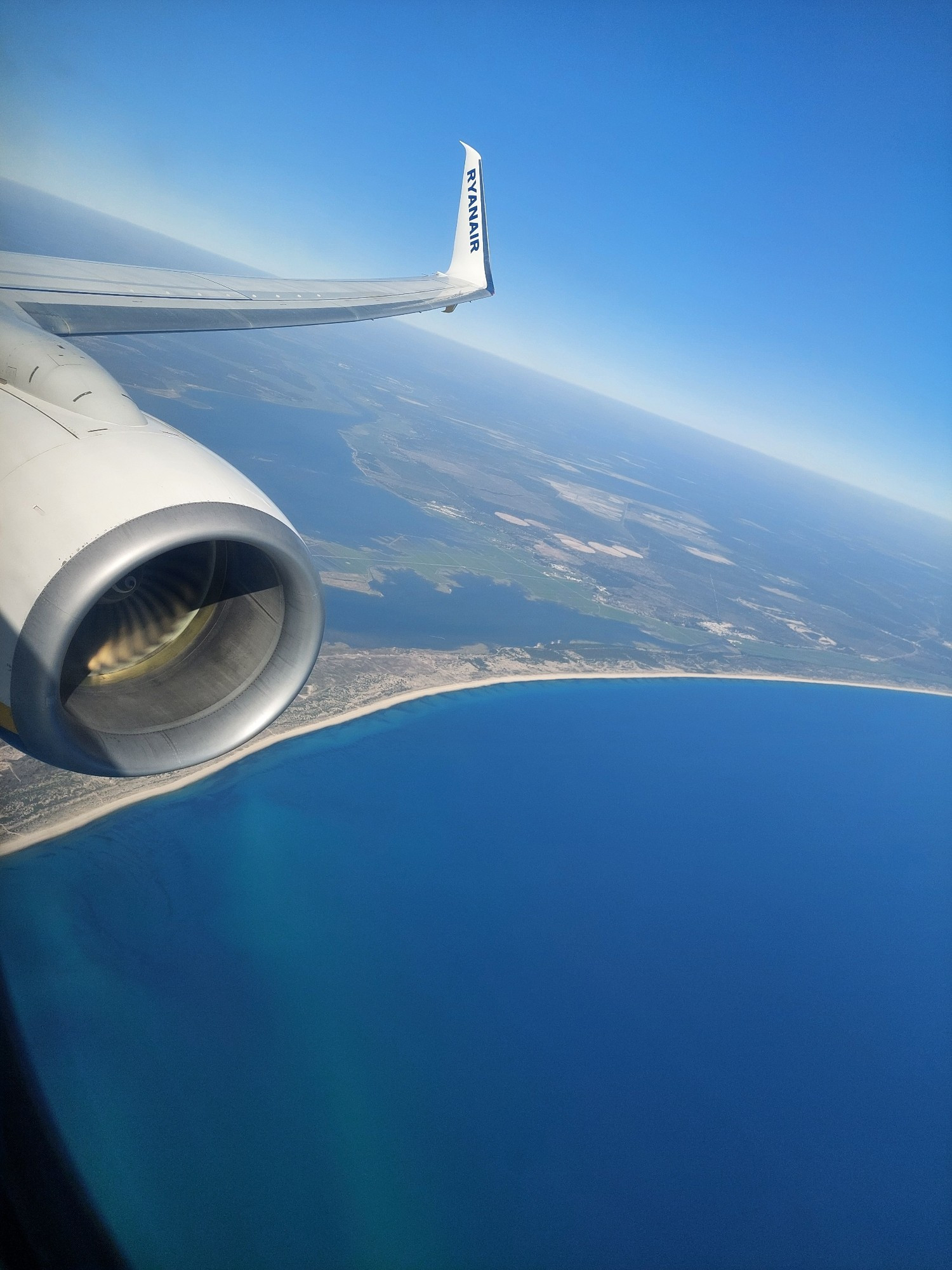 Blick aus dem Flugzeugfenster auf Meer und ein Stück Küste