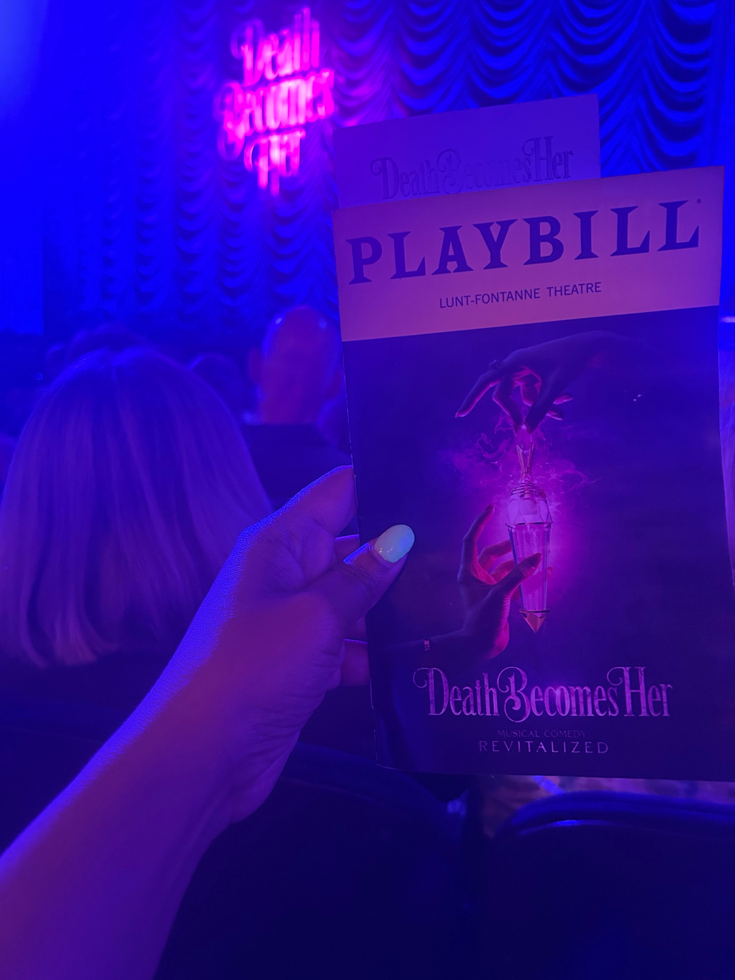 A picture of my hand holding the playbill for death becomes her 