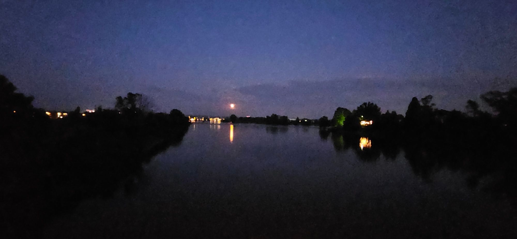 Ein Bild der Flutrinne in Dresden Kaditz mit der Silhoutte von Pieschen. Es sieht aus wie ein normaler, ziemlich breiter Fluss.