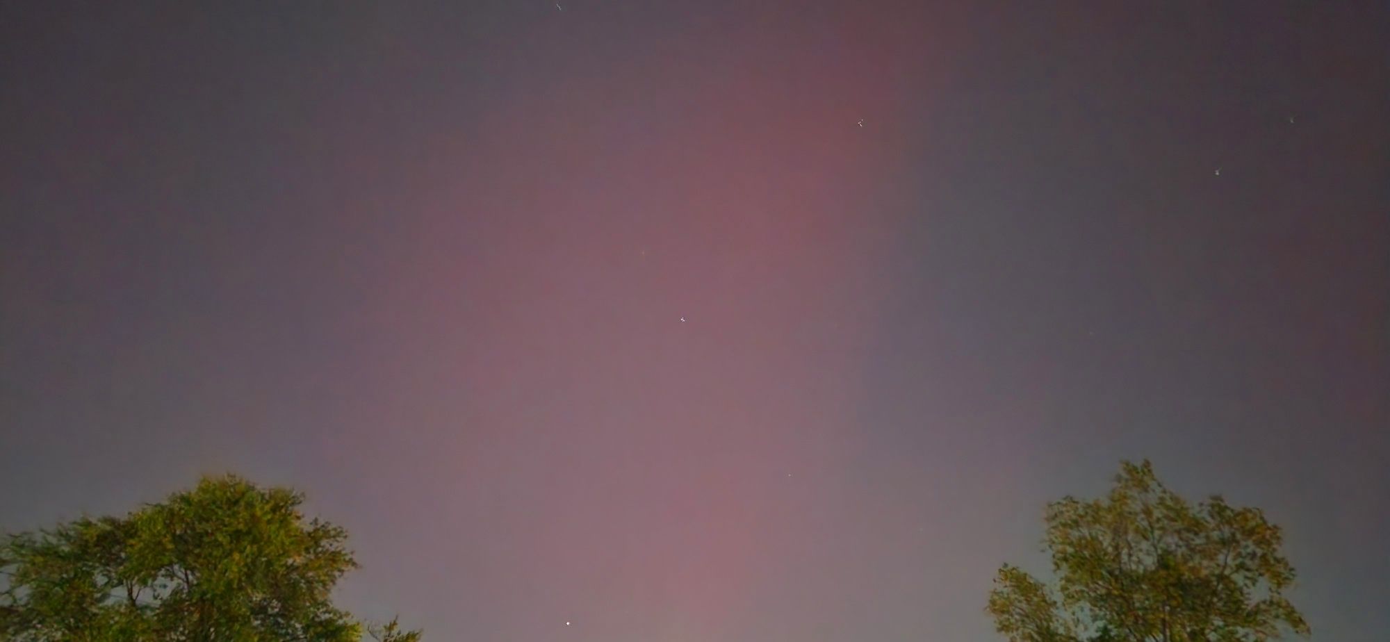 A night sky with pink ha,e in the middle