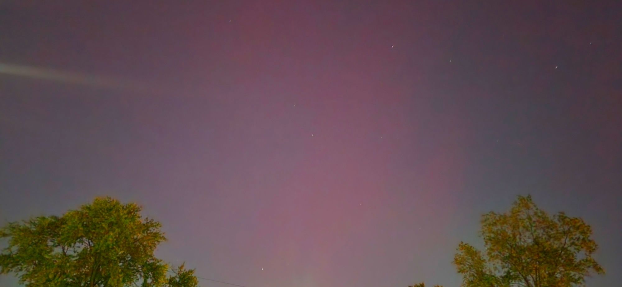 A night sky with a pink haze