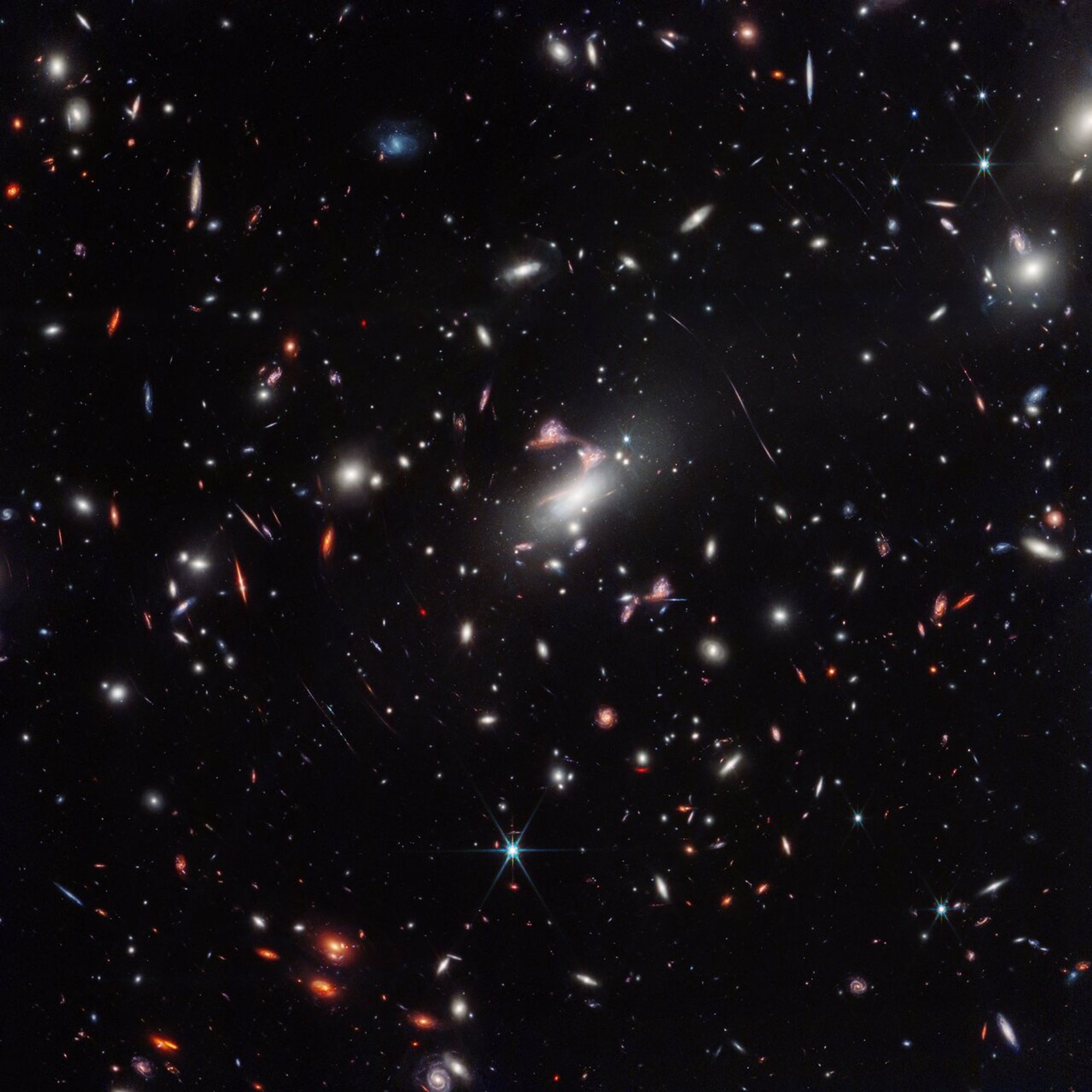 A cosmic question mark appears amid a powerful gravitational lens in the James Webb Space Telescope’s wide-field view of the galaxy cluster MACS-J0417.5-1154. Gravitational lensing occurs when something is so massive, like this galaxy cluster, that it warps the fabric of space-time itself, creating a natural funhouse-mirror effect that also magnifies galaxies behind it.

The rarely seen type of lensing captured here, which astronomers term hyperbolic umbilic, created five repeated images of one galaxy pair. The red, elongated member of this pair traces the familiar shape of a question mark across the sky due to the distortion, with another unrelated galaxy happening to be in just the right space-time to appear like the question mark’s dot – especially for humans who love to recognize familiar shapes and patterns.