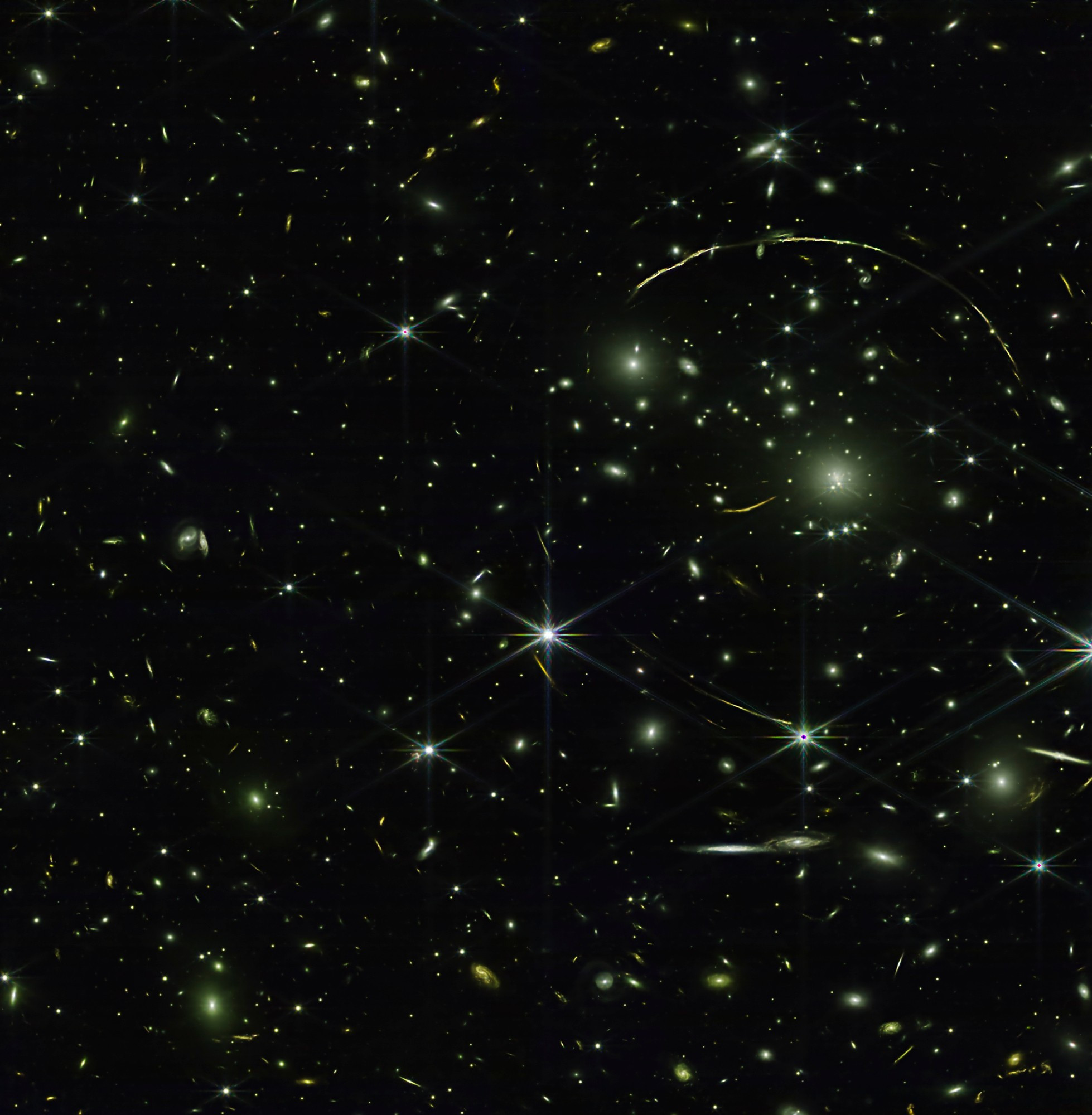 This near-infrared image, taken by the James Webb Space Telescope (JWST), showcases a cluster of galaxies. The foreground galaxy cluster acts as a giant gravitational lens, distorting the light of galaxies behind it.