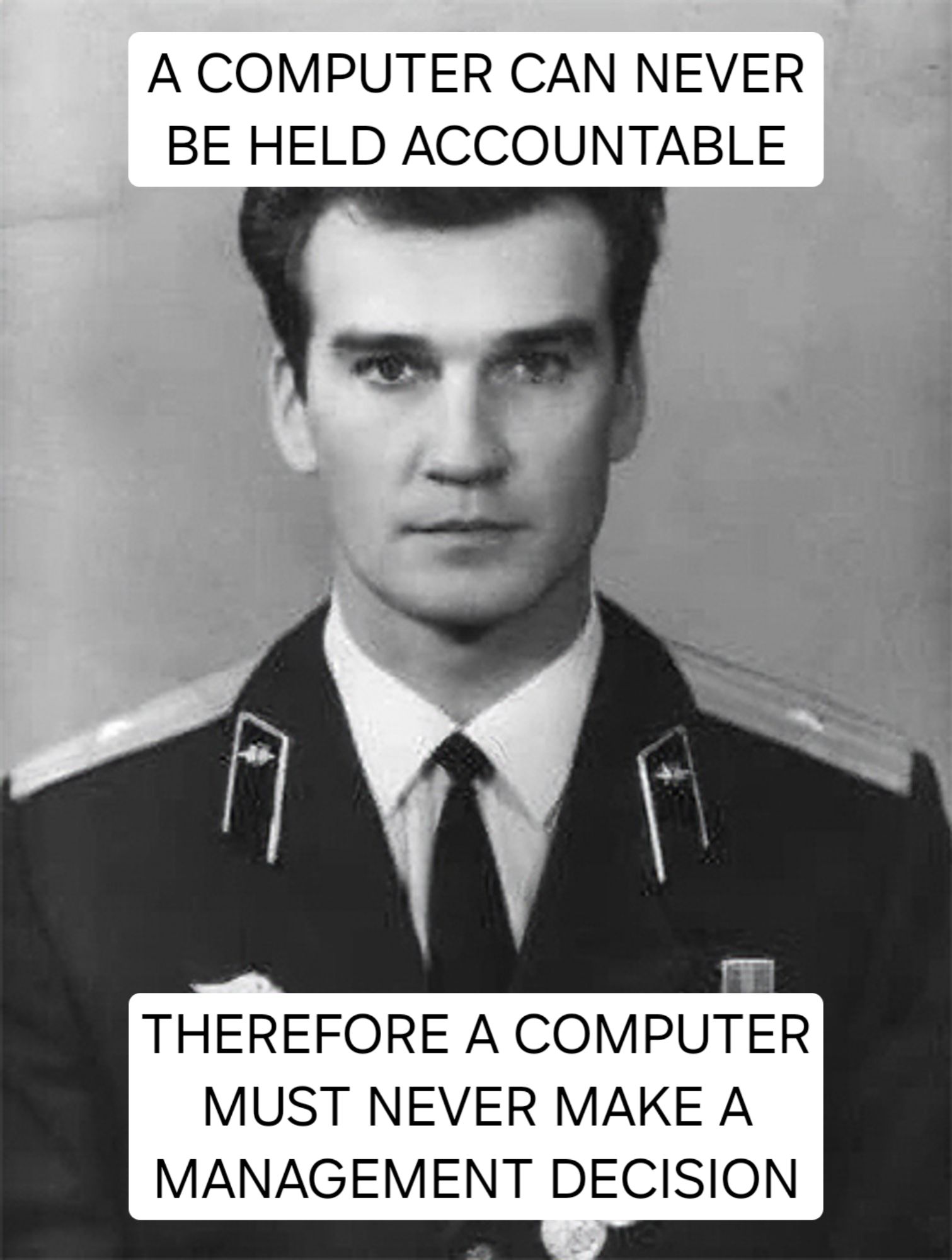 Stanislav Petrov, a young Russian man in a military uniform, with the words "A COMPUTER CAN NEVER BE HELD ACCOUNTABLE, THEREFORE A COMPUTER MUST NEVER MAKE A MANAGEMENT DECISION"