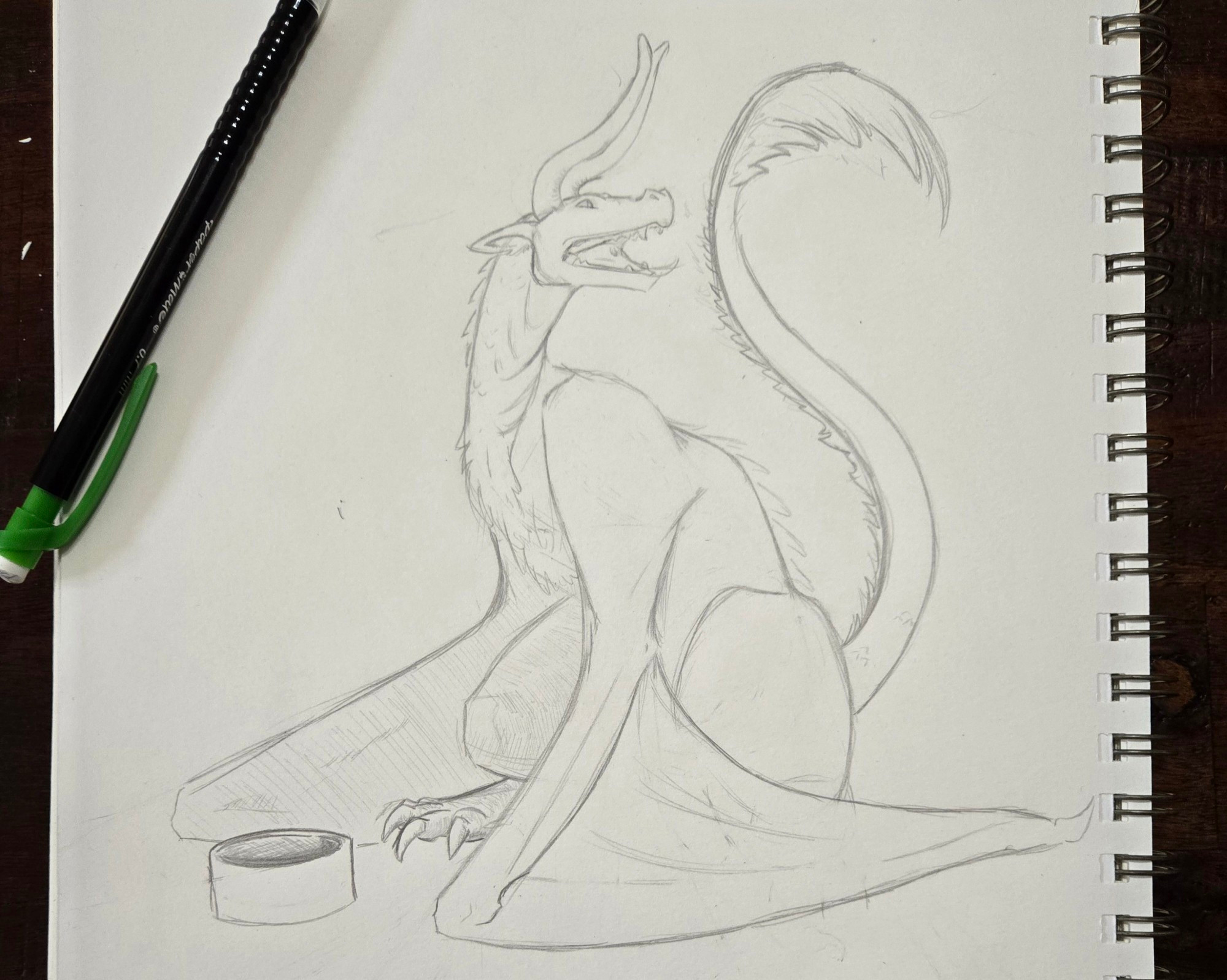 A penciled dragon (wyvern) looking plaintively offscreen with an empty bowl in front of them.