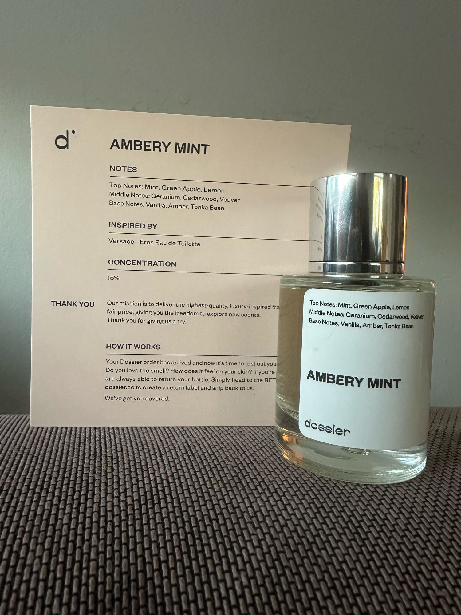 Image of the Ambery Mint perfume from Dossier with its description card. 

Top notes: mint, green apple, lemon
Mid notes: geranium, cedar wood, vetiver
Base notes: vanilla, amber, tonka