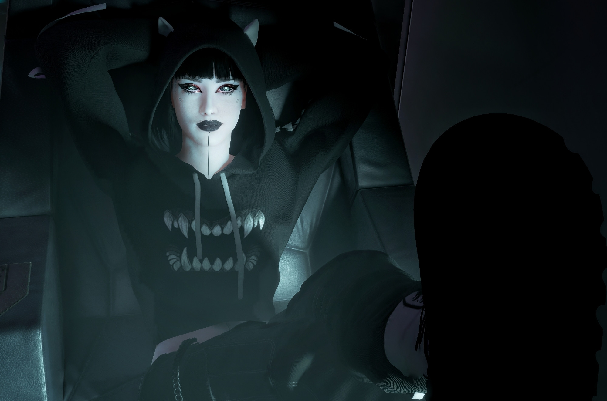 A goth woman wearing a black hoodie with cat ears and teeth motif