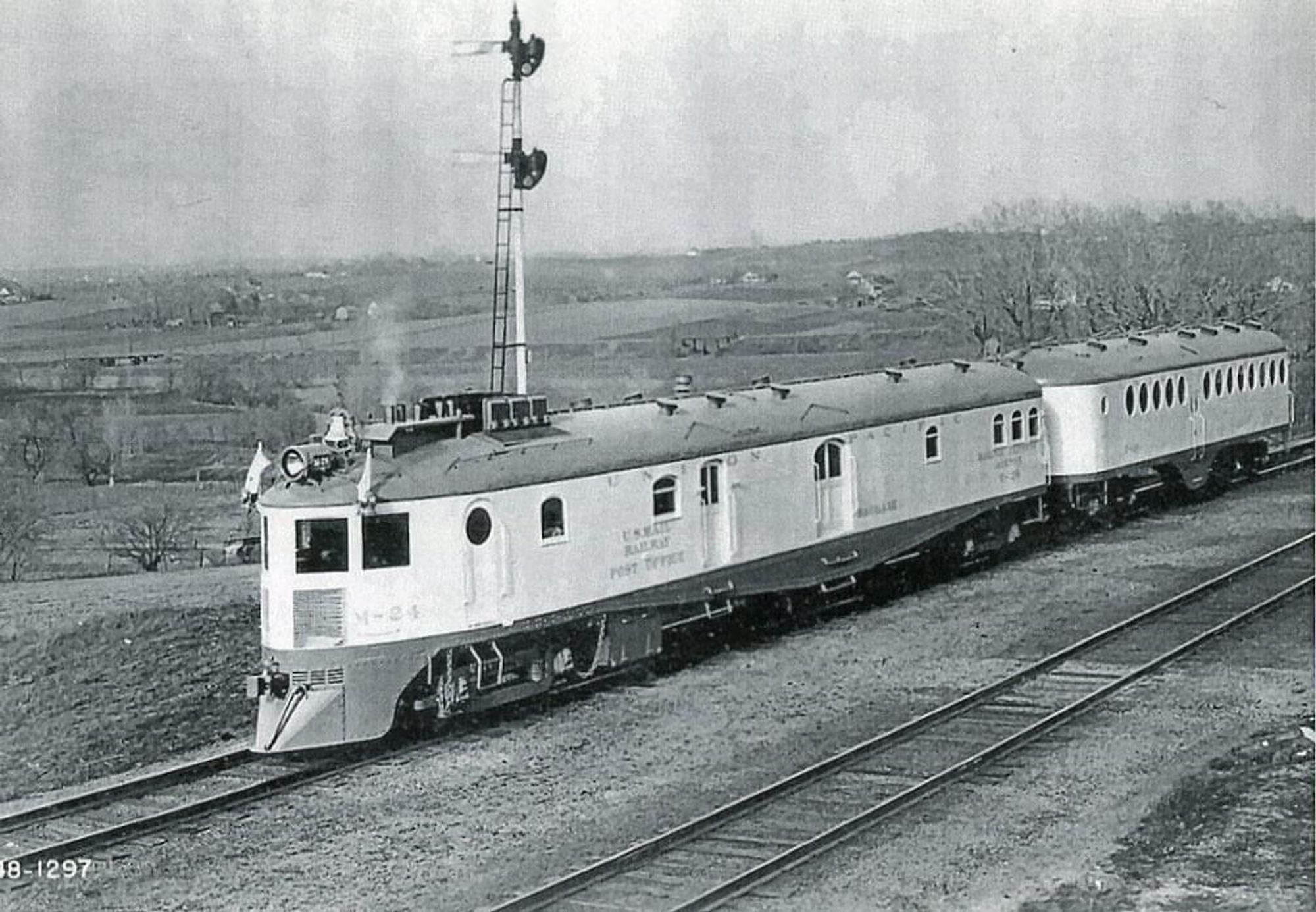 A Union Pacific RR McKeen motorcar poses for a company photographer, with its lovely porthole festooned passenger "trailer" behind. Painted UP Armour Yellow, with either leaf brown or gray underframe/roof.