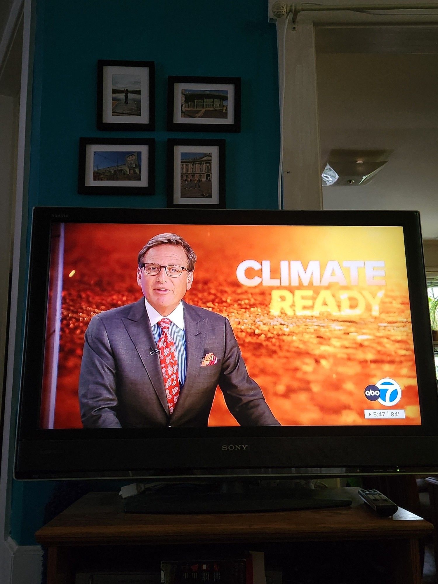 The ABC news anchor, a white man in a suit and glasses, juxtaposed against a fiery looking background with the words "climate ready"