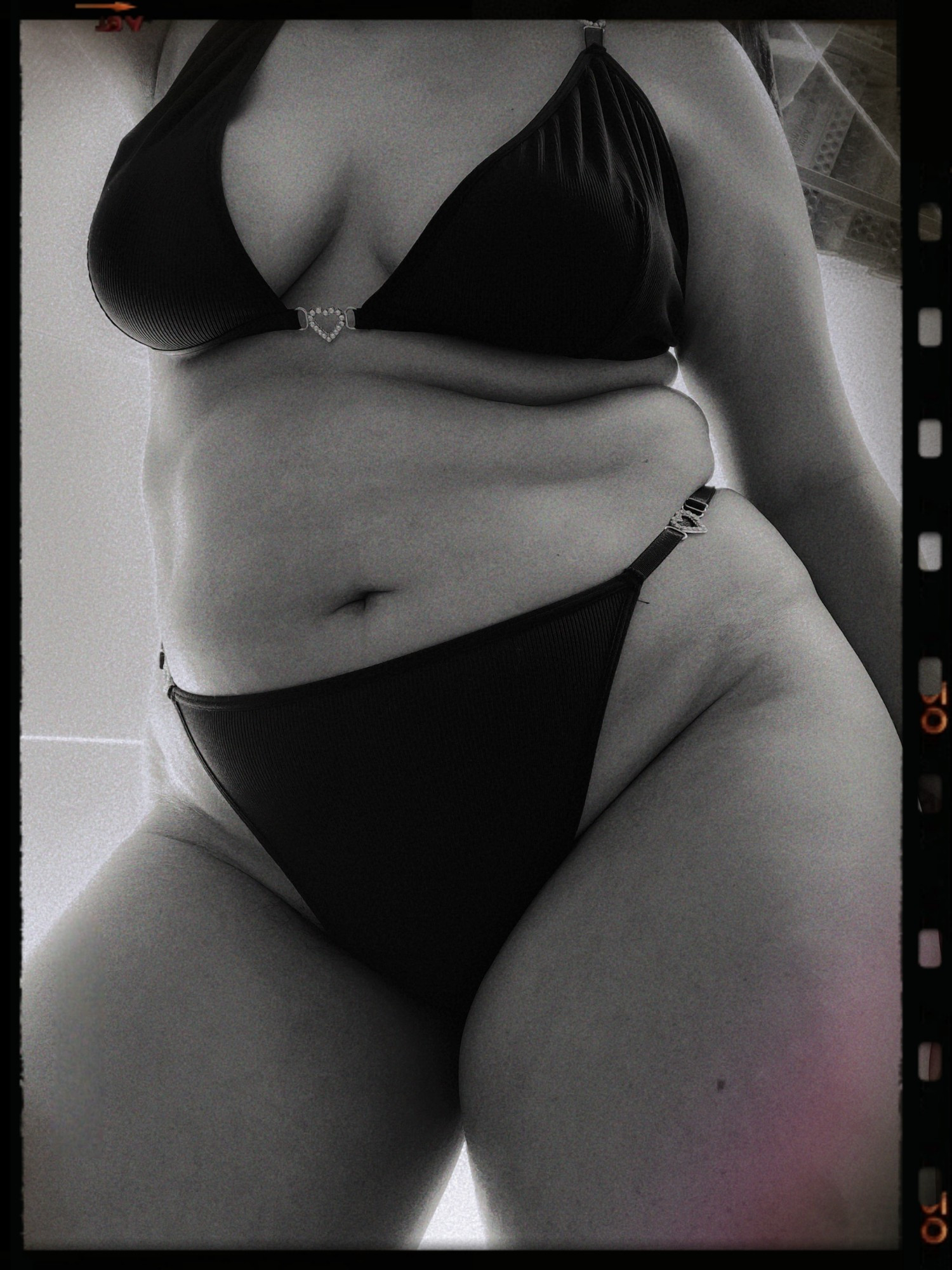 The black-and-white image shows a close-up, low-angle view of a person wearing a bikini, highlighting their belly. The bikini top features a small heart-shaped detail, and the high-cut bottoms have metallic hearts at the hips. The image has a vintage, grainy texture with a film reel border.

🧡🖤🧡 🖤🧡🖤

Mexican Fat FTM Trans Plus Size Belly Weight Gain Chubby Tummy POV Nudity Nudism Tits Monochome BHM