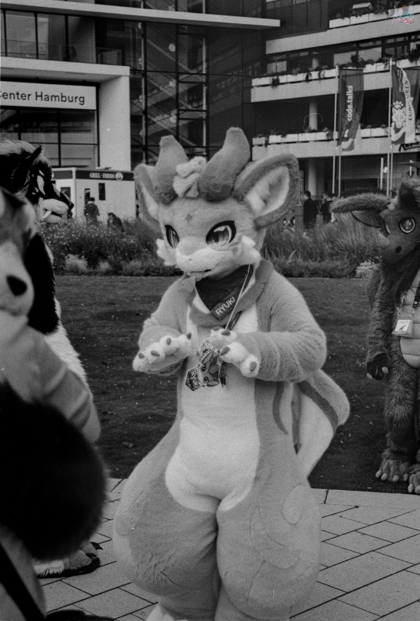 Ryuki, a kemono Dragon (?) standing on the square in front of the CCH, next to some other suiters.