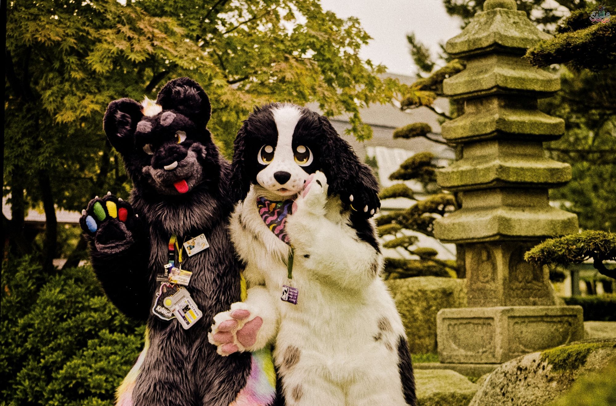 Two suiters, Kianga on the left and Coco (Purple) on the right, standing next to one of the stone pagodas in the Japanese garden section of Planten un Blomen in Hamburg.