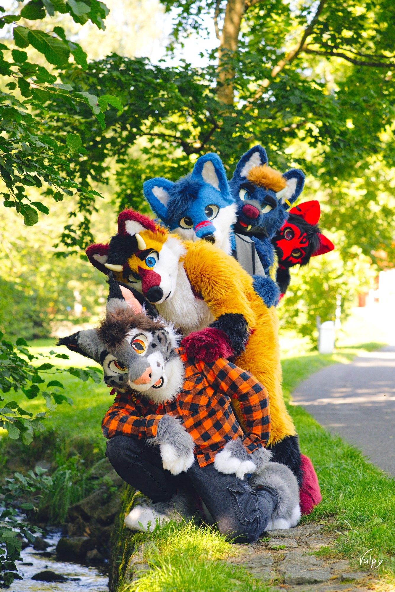 A picture of 5 suiters standing behind each other but slightly offset. Just so much as to look over the shoulder of the one in front of them. Making a nice bouquet of Fursuiters.