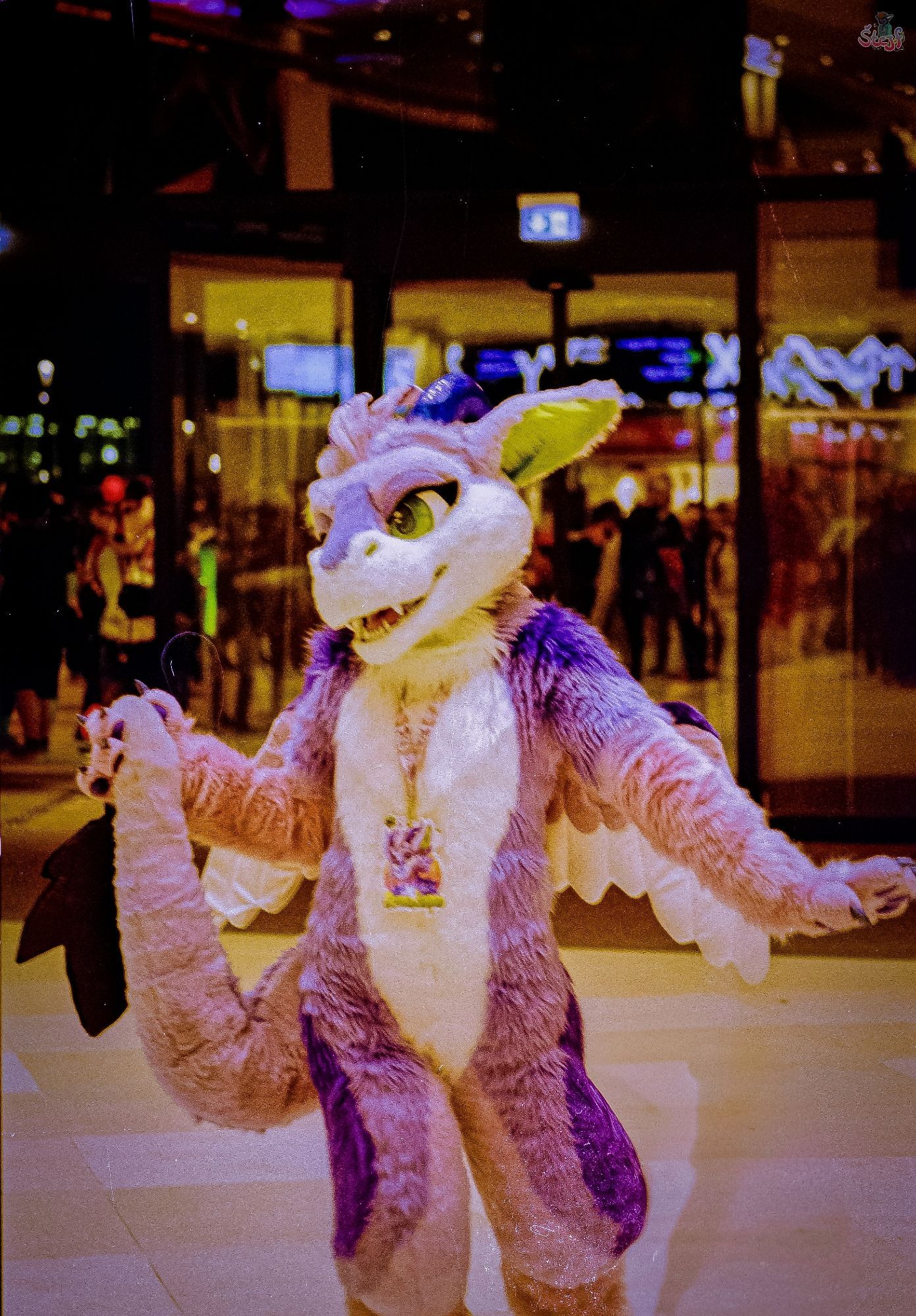 A dragon Fursuiter standing in front of the doors to the outside of the CCH.