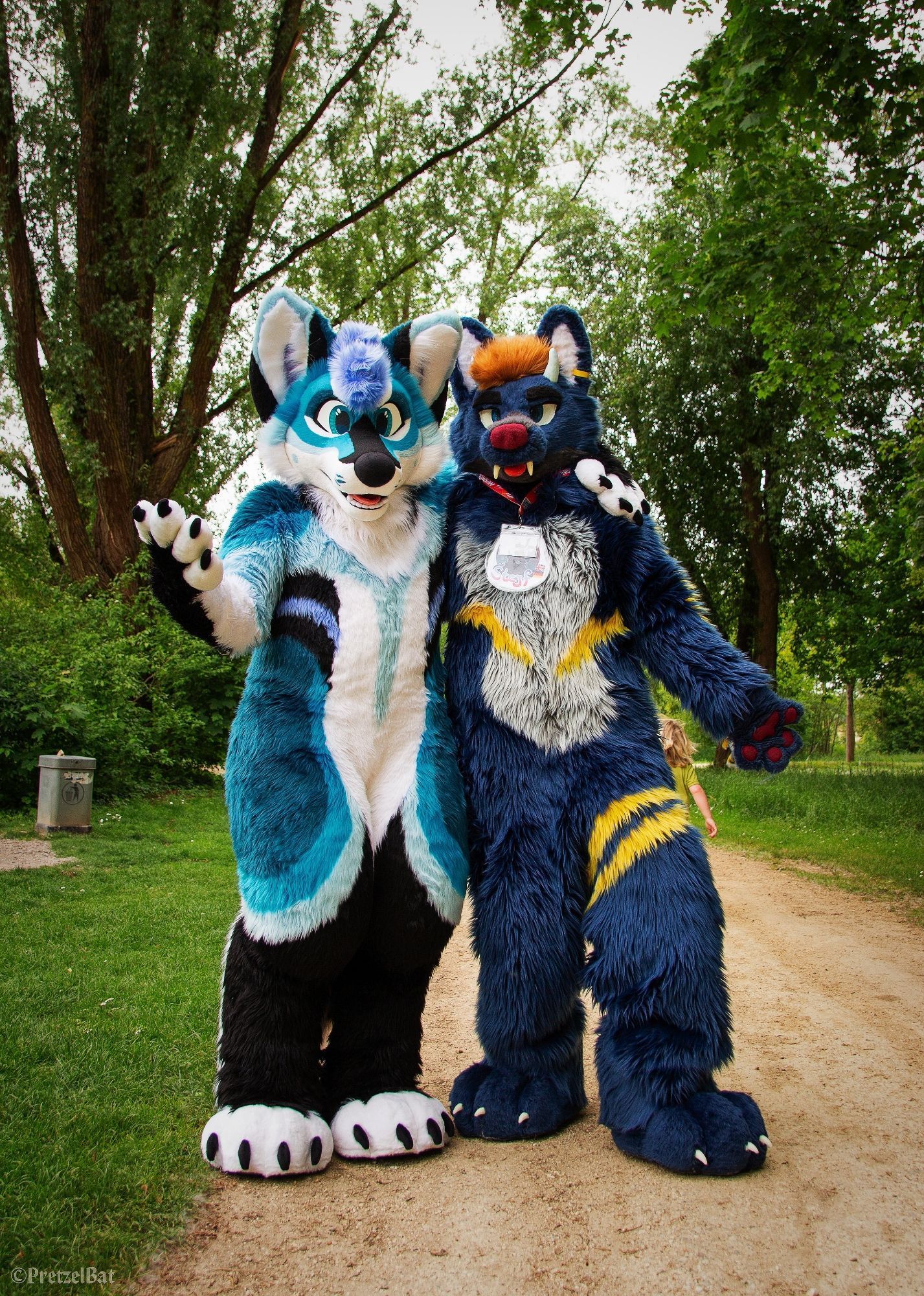 A picture of two suiters standing in a park, looking directly at the viewer.