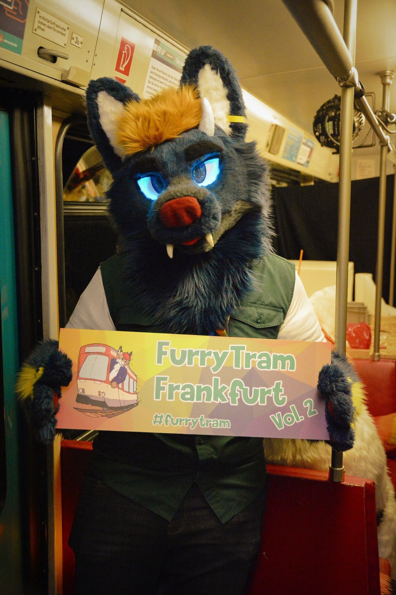 A picture of me in suit, holding the official™ Furry Tram Frankfurt sign.