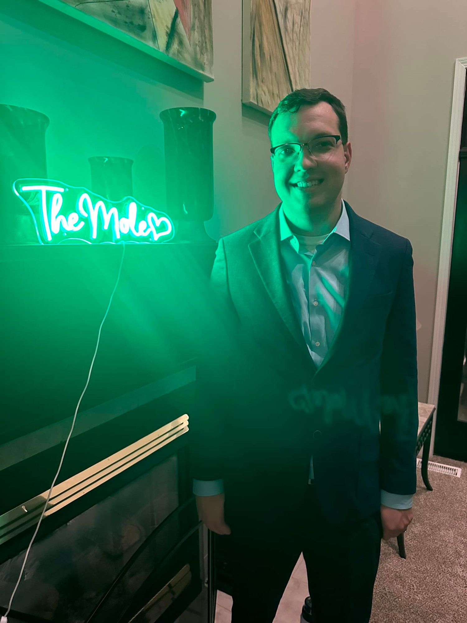 Me in a nice suit standing next to a green neon sign that says "The Mole."