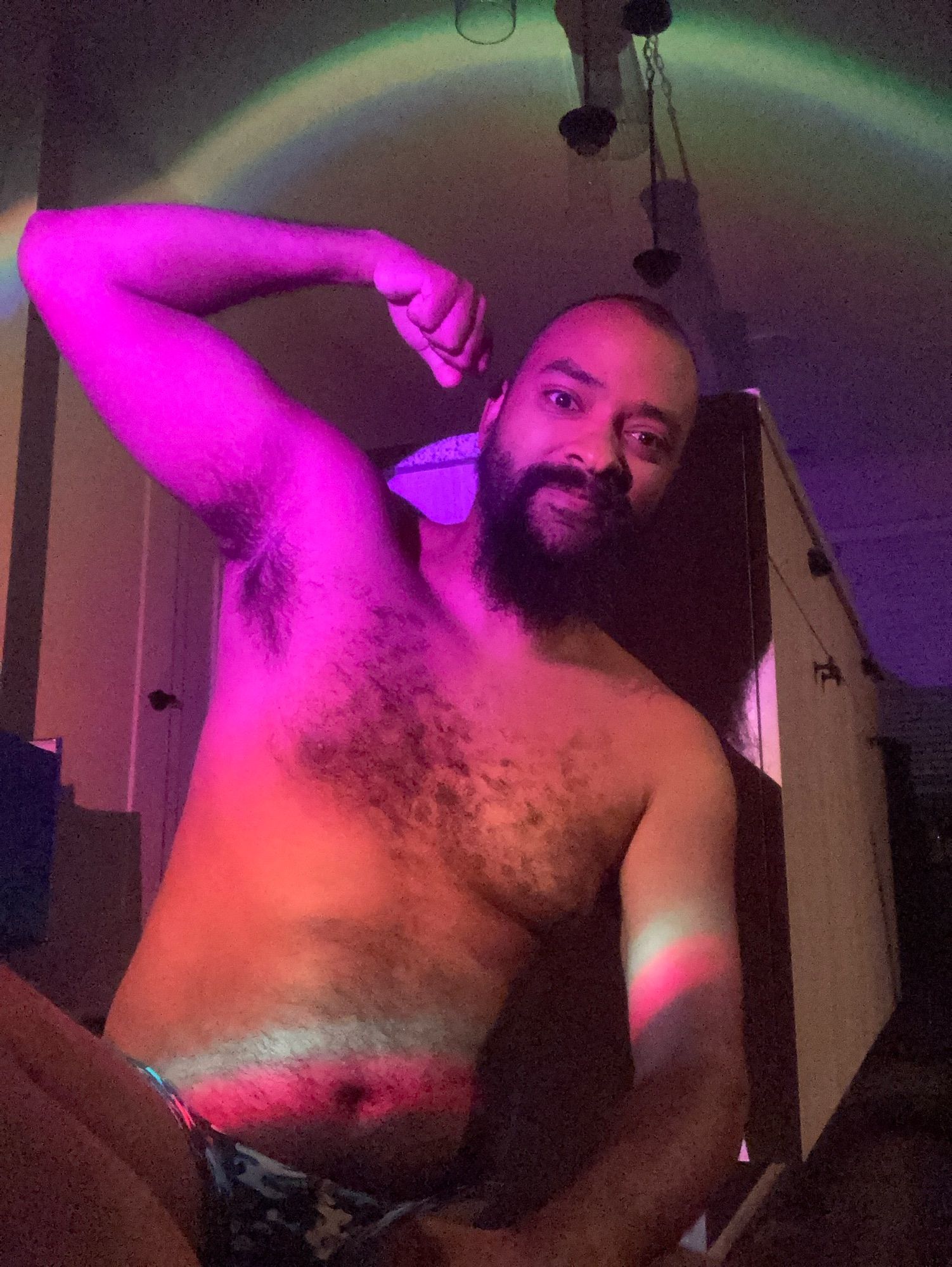 Bearded shirtless gentleman flexes exposing his armpit. 