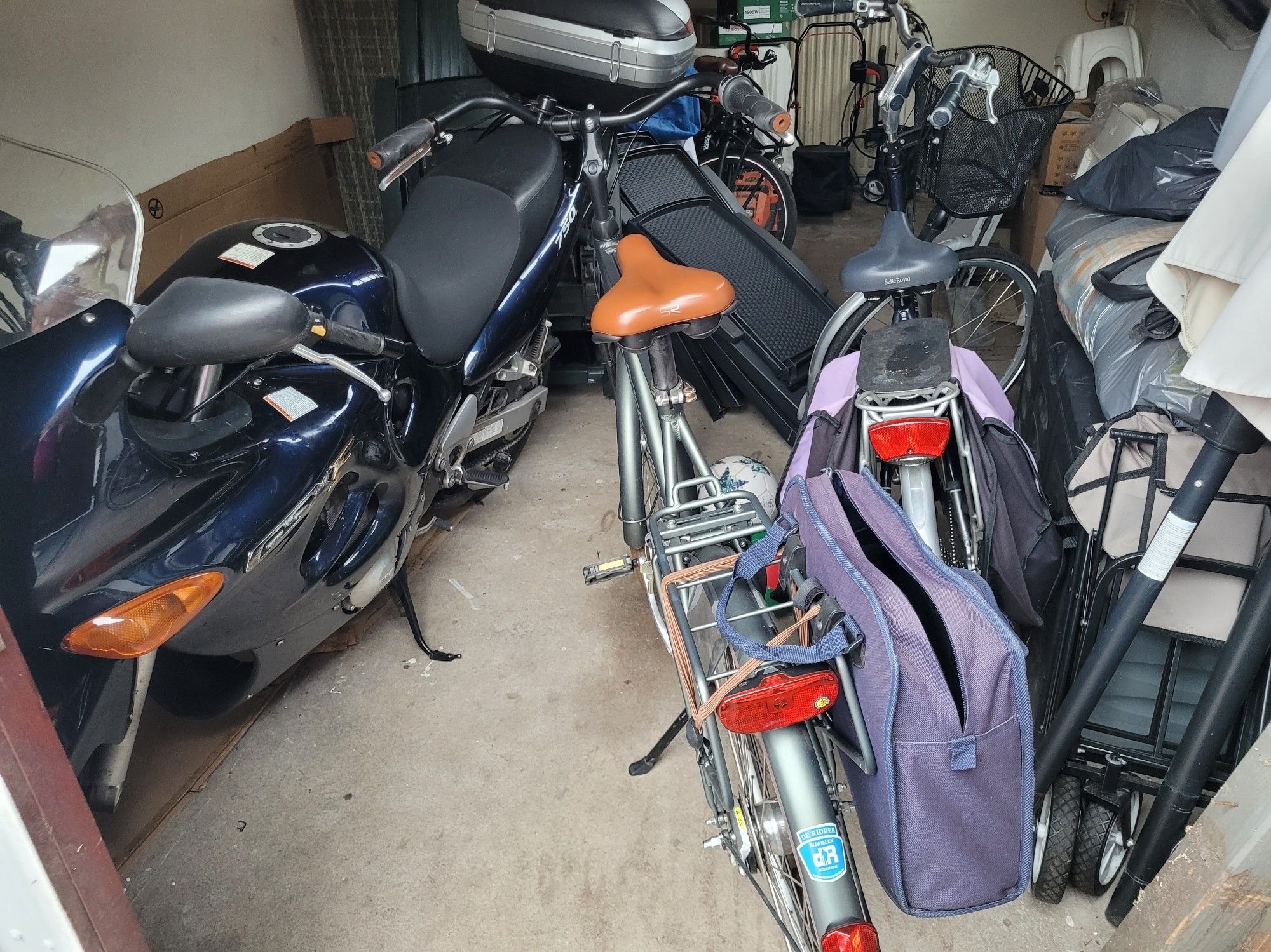 View inside a garage of a motorcycle & two bicycles.