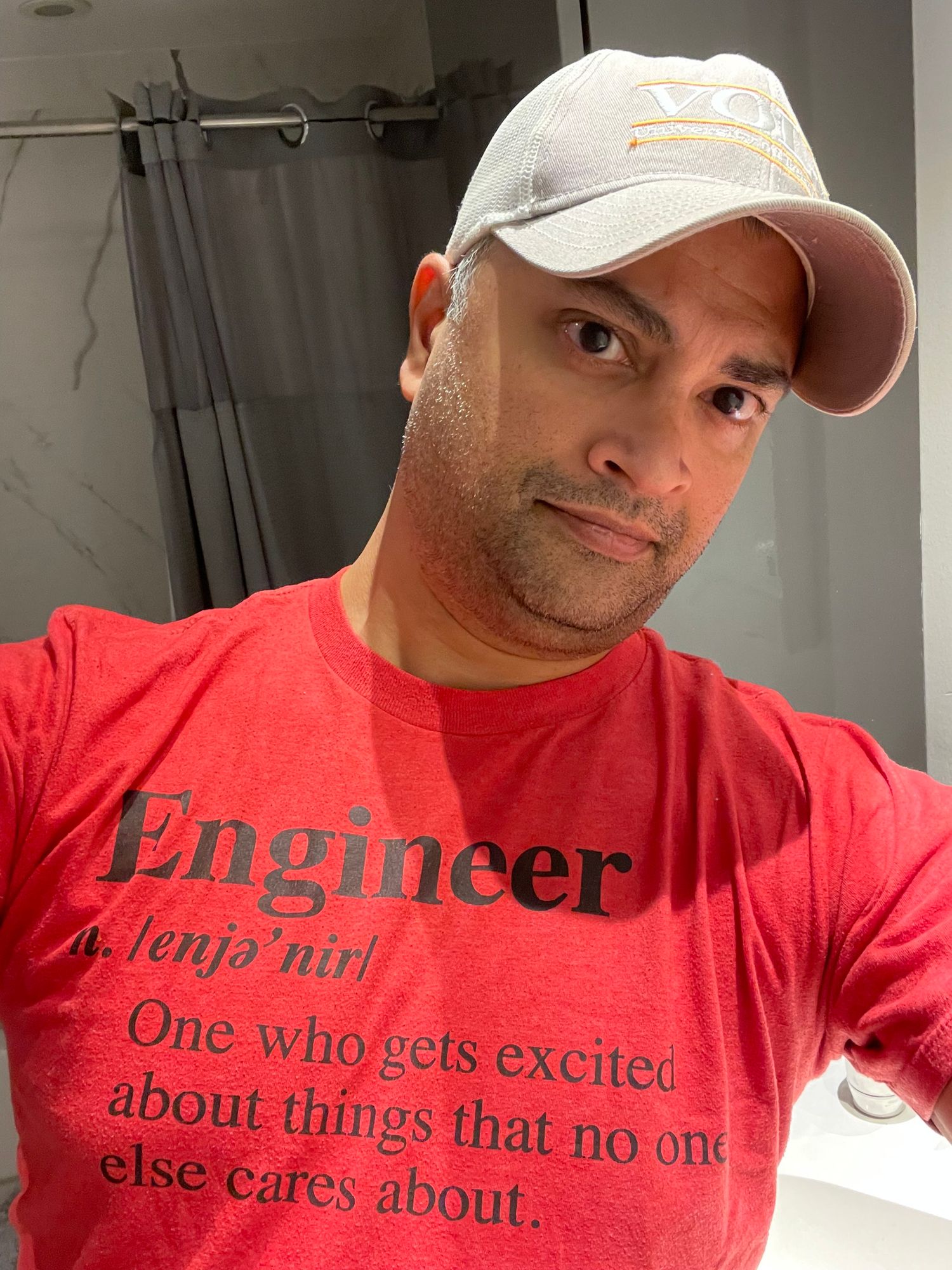 Tennessee Vols hat on the head of transcendental South Asian-looking scholar, comedian and influencer with a T-shirt that reads
Engineer
a. enja-nir
One who gets excited about things that no one else cares about.