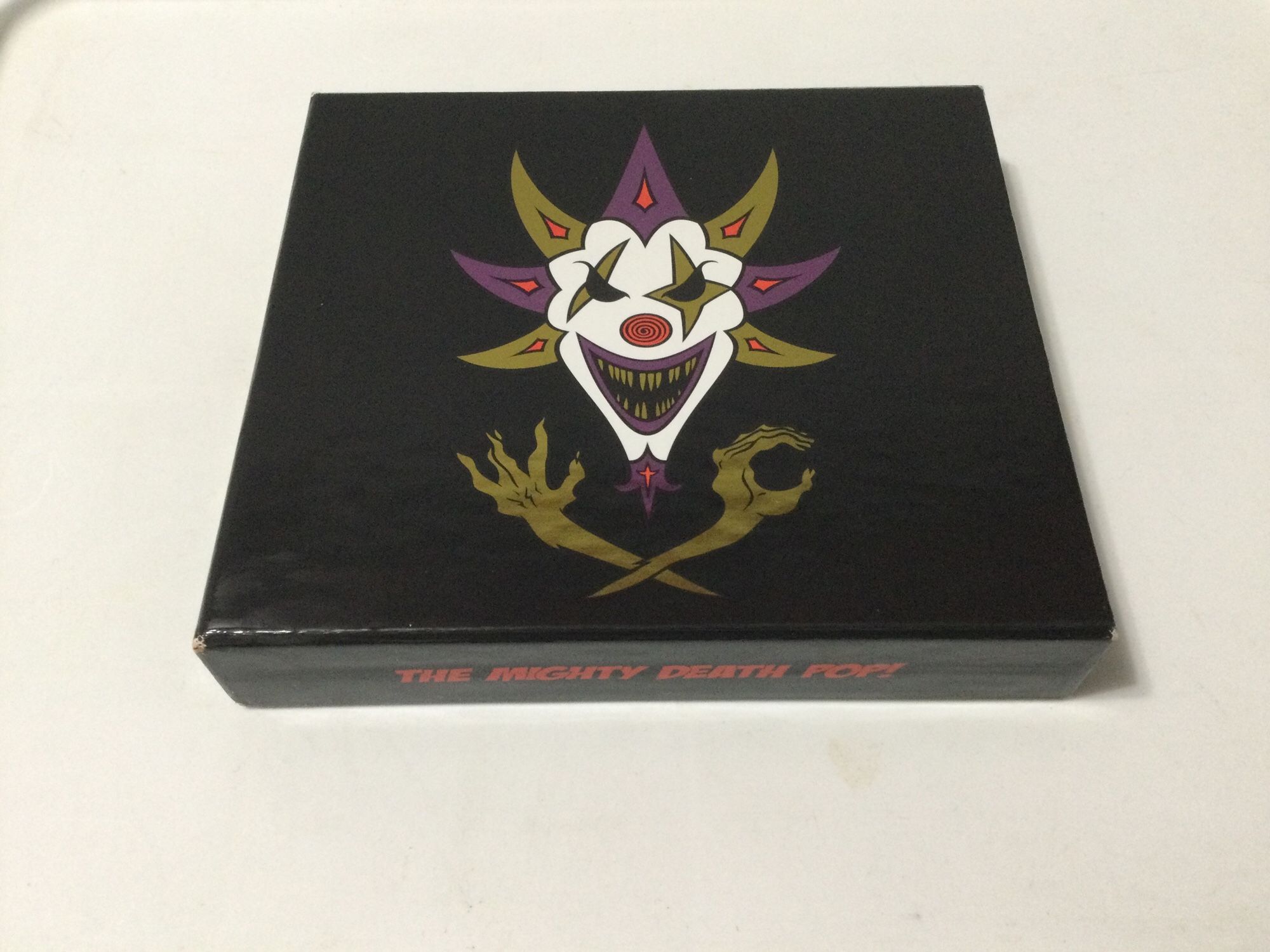 A copy of The Mighty Death Pop (Black Pop Boxset) by Insane Clown Posse, released in 2012 under Psychopathic. The boxset comes  with the CD of The Mighty Death Pop album and a bonus CD, Freaky Tales.