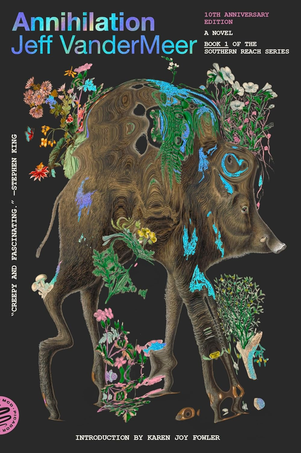 Cover of the book “Annihilation” by Jeff VanderMeer, featuring a distorted image of a boar with flowers, foliage, and abstract elements, celebrating the 10th anniversary edition. Includes a quote (“Creepy and fascinating”) by Stephen King and introduction by Karen Joy Fowler