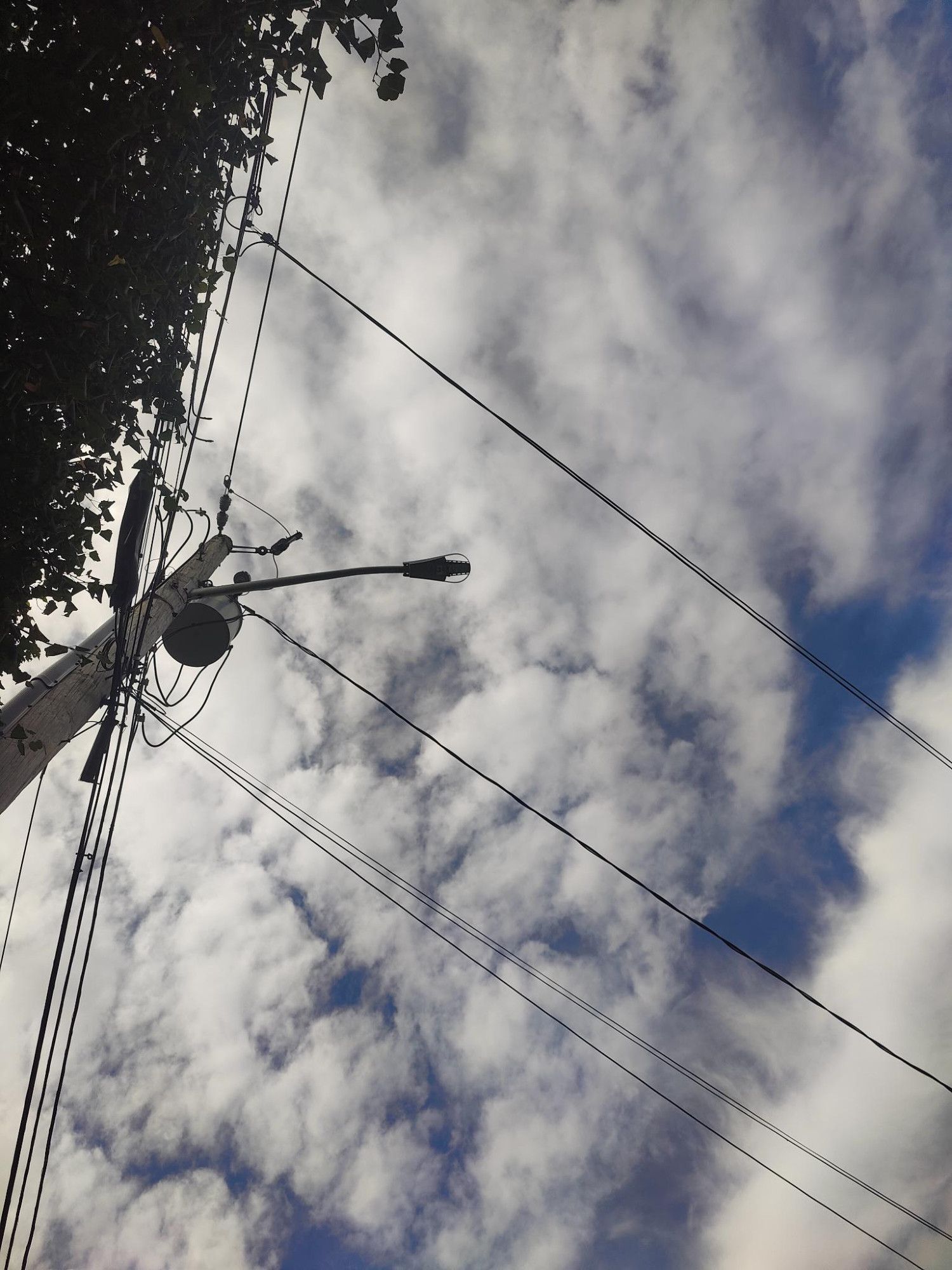 A PHOTO OF A BLOBULAR SKY W/ A TELEPHONE POLE AGAINST IT