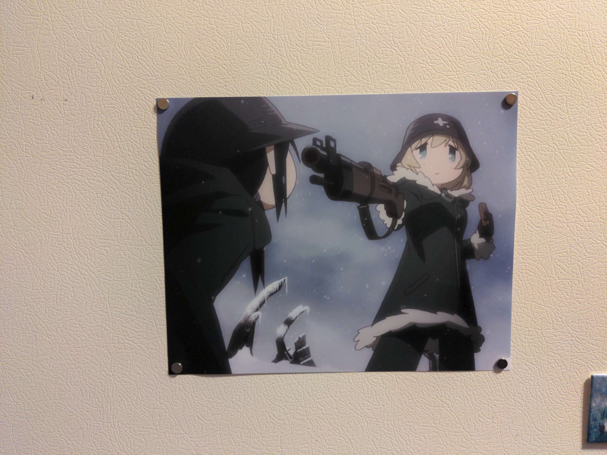 Screencap from the anime "Girls Last Tour" printed and stuck on the front of my freezer with magnets. Shows Yuuri pointing her 6.5mm rifle at Chi as she holds the last ration.